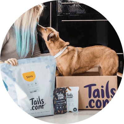 A tails.com customer with her dog and her tails.com dry, wet and treats