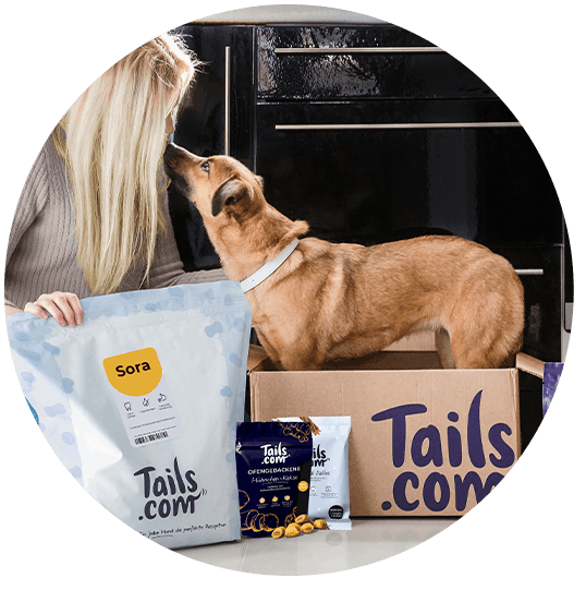 Eine tails.com Kundin mit tails.com Futter, Leckerli und Nassfutter