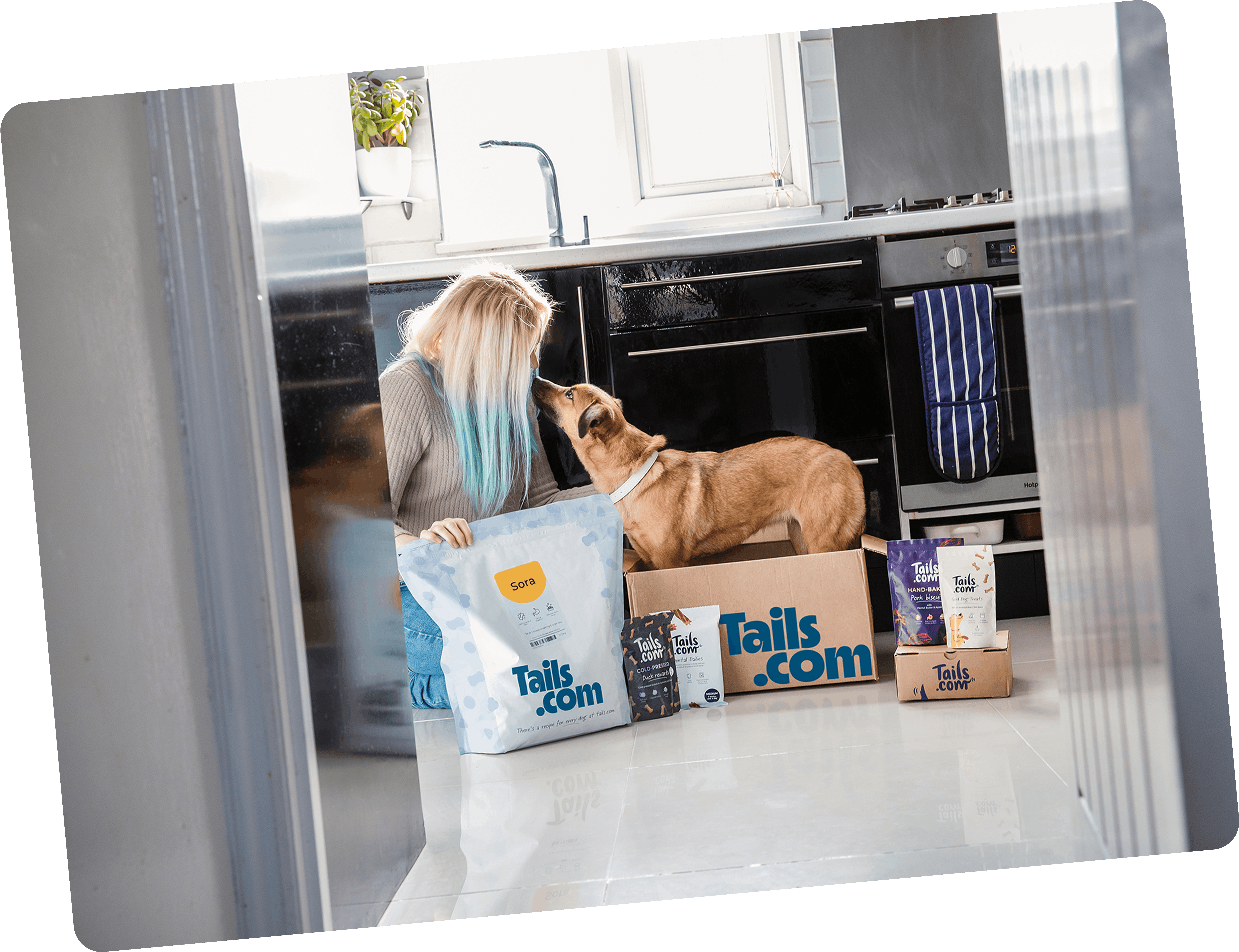 Girl with her dog and tails.com products and delivery box