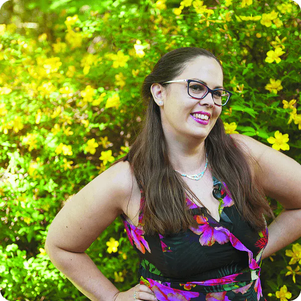 Vet Nurse outside in front of a green and yellow bush