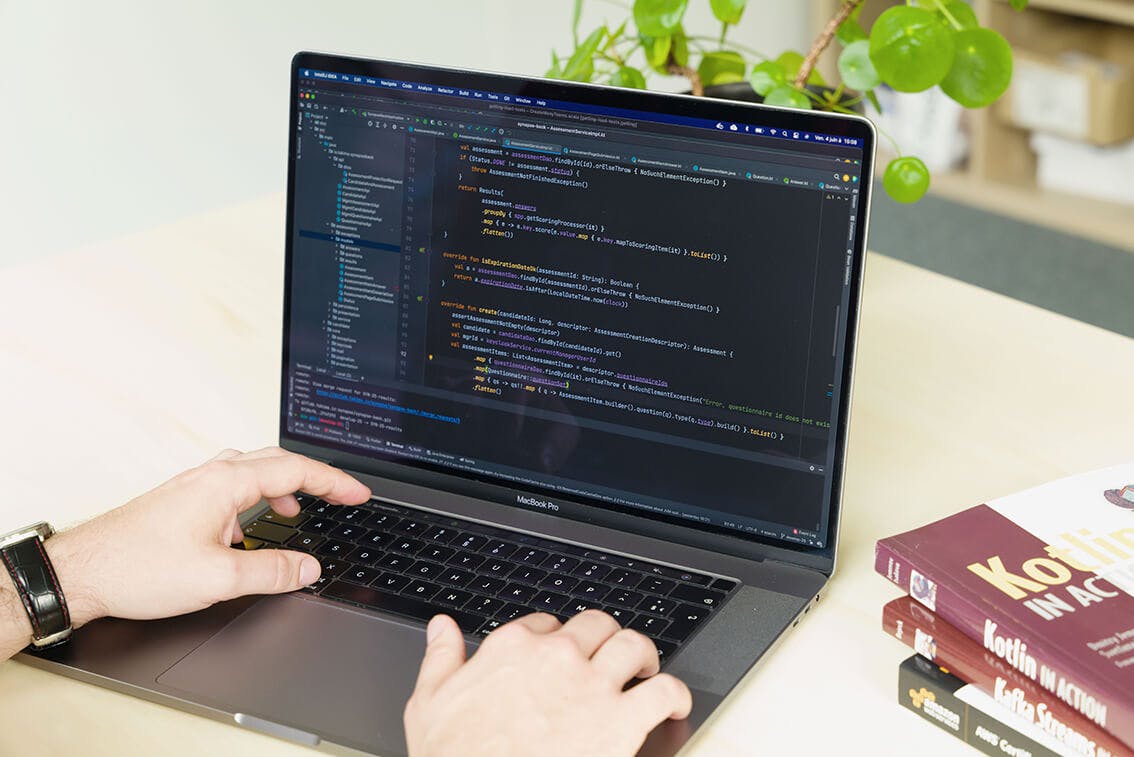 Groupe de quatre collègues souriants regardant une tablette autour d’une table