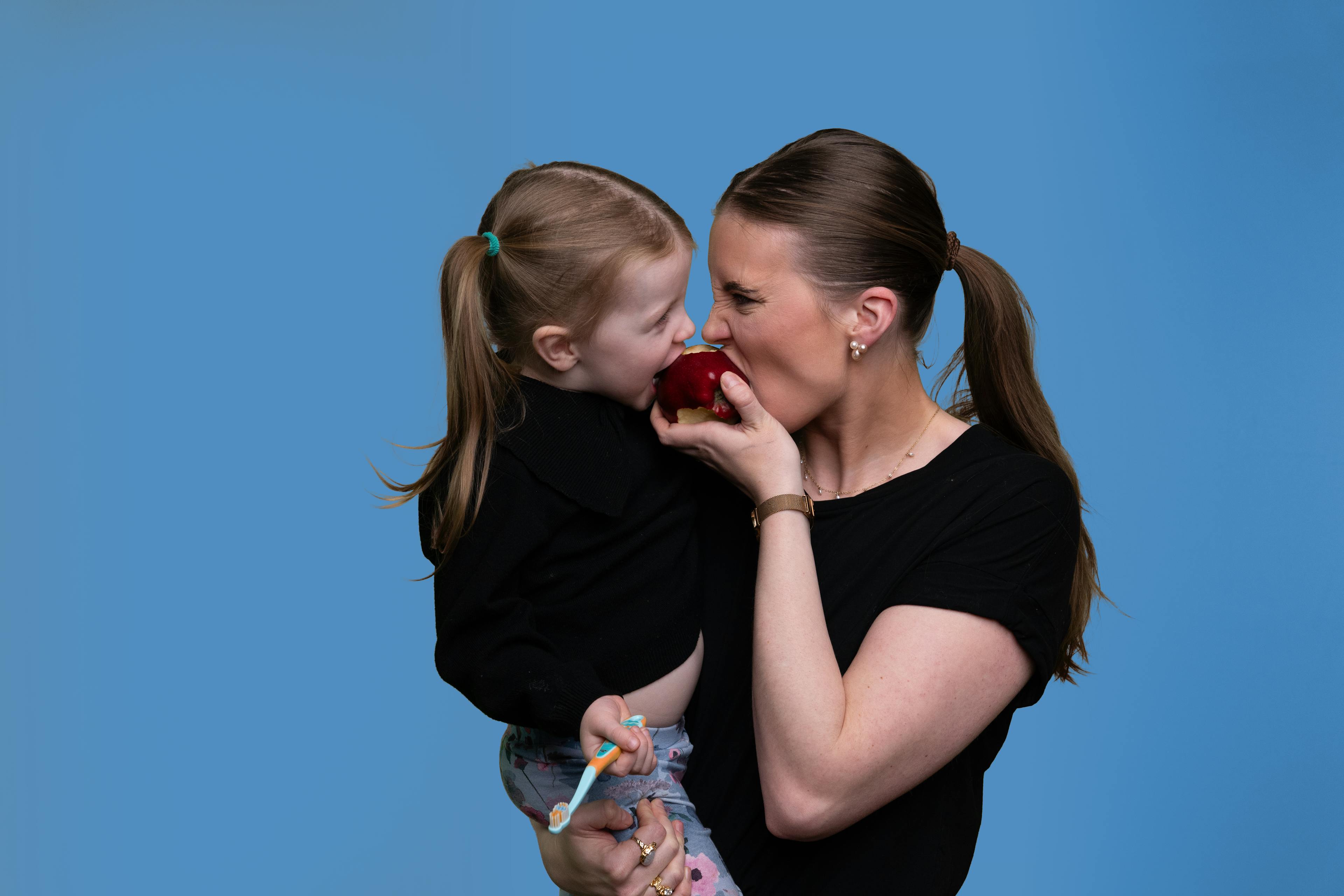 Mother and her child eating an apple 
