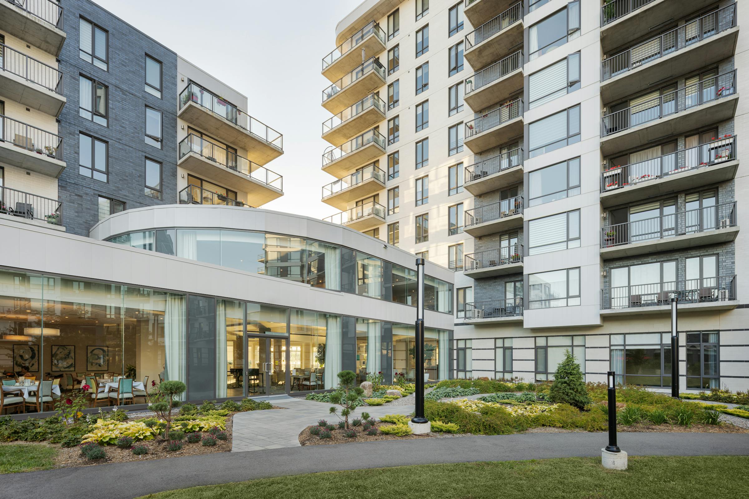 At sunset, photograph of the architecture and landscaping of a multi-residential building.