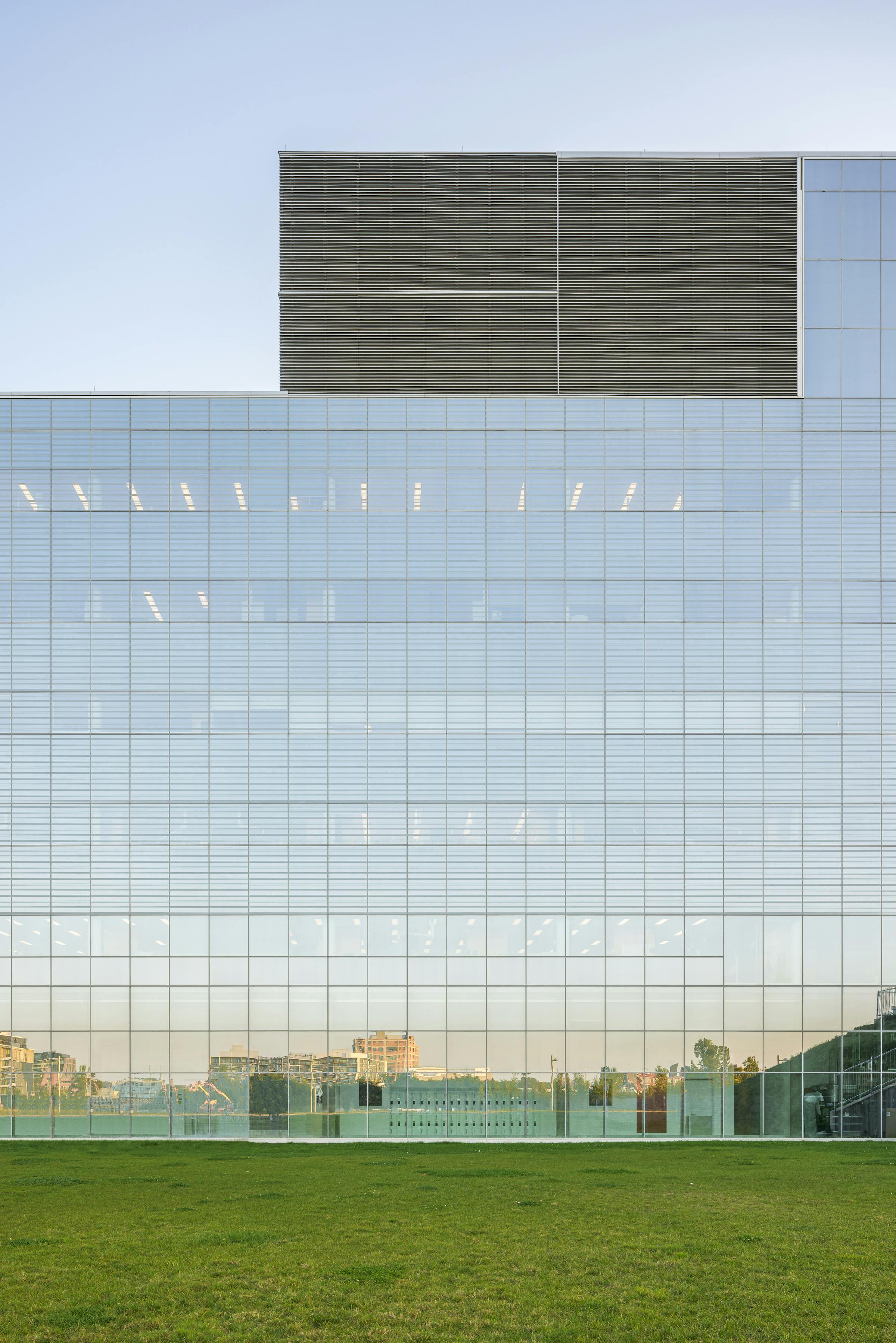 Photograph of a glass facade with the reflection of the surroundings.