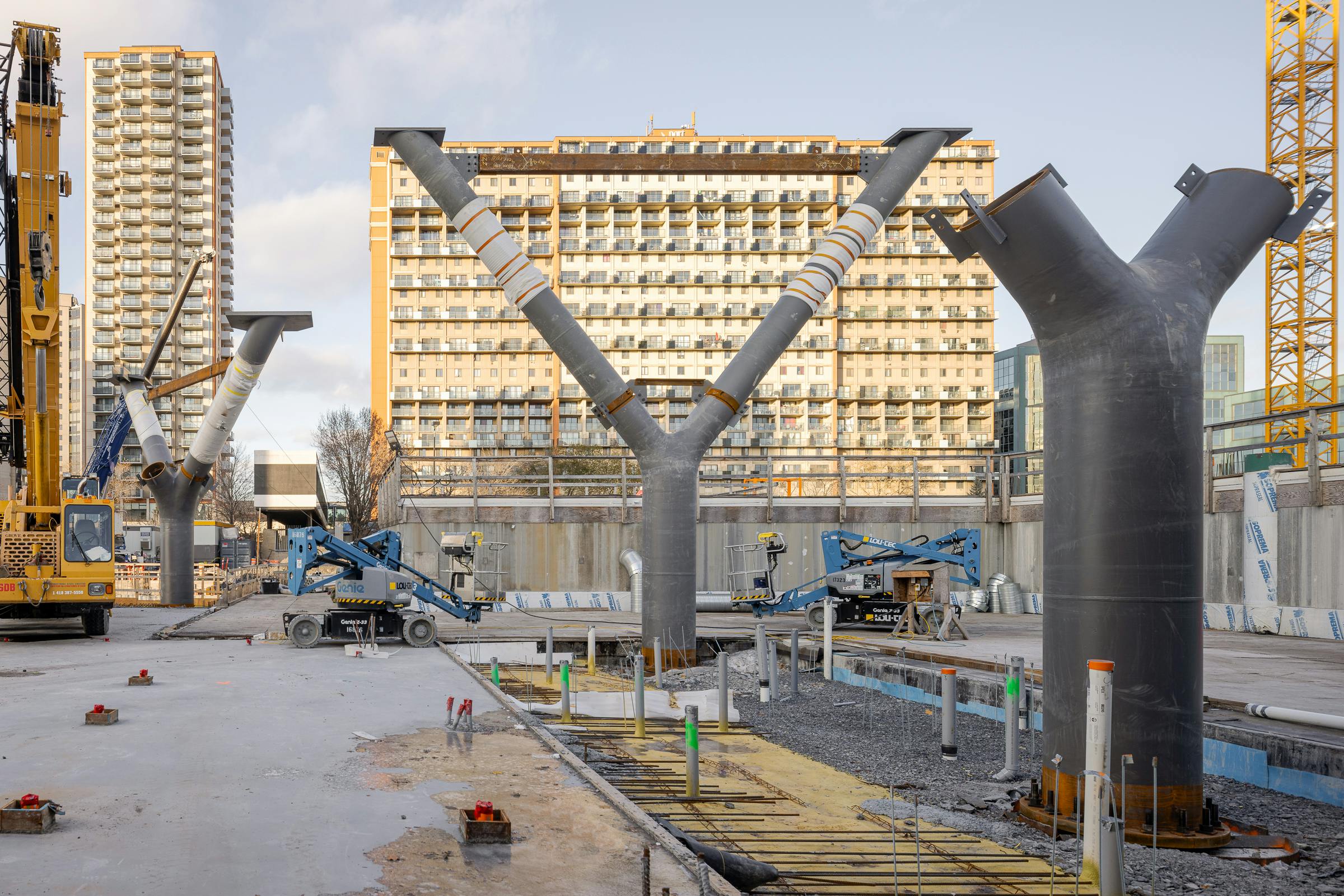 Trois structures en acier destinées à recevoir des fermes métalliques sur un chantier de construction dans le région de Montréal.