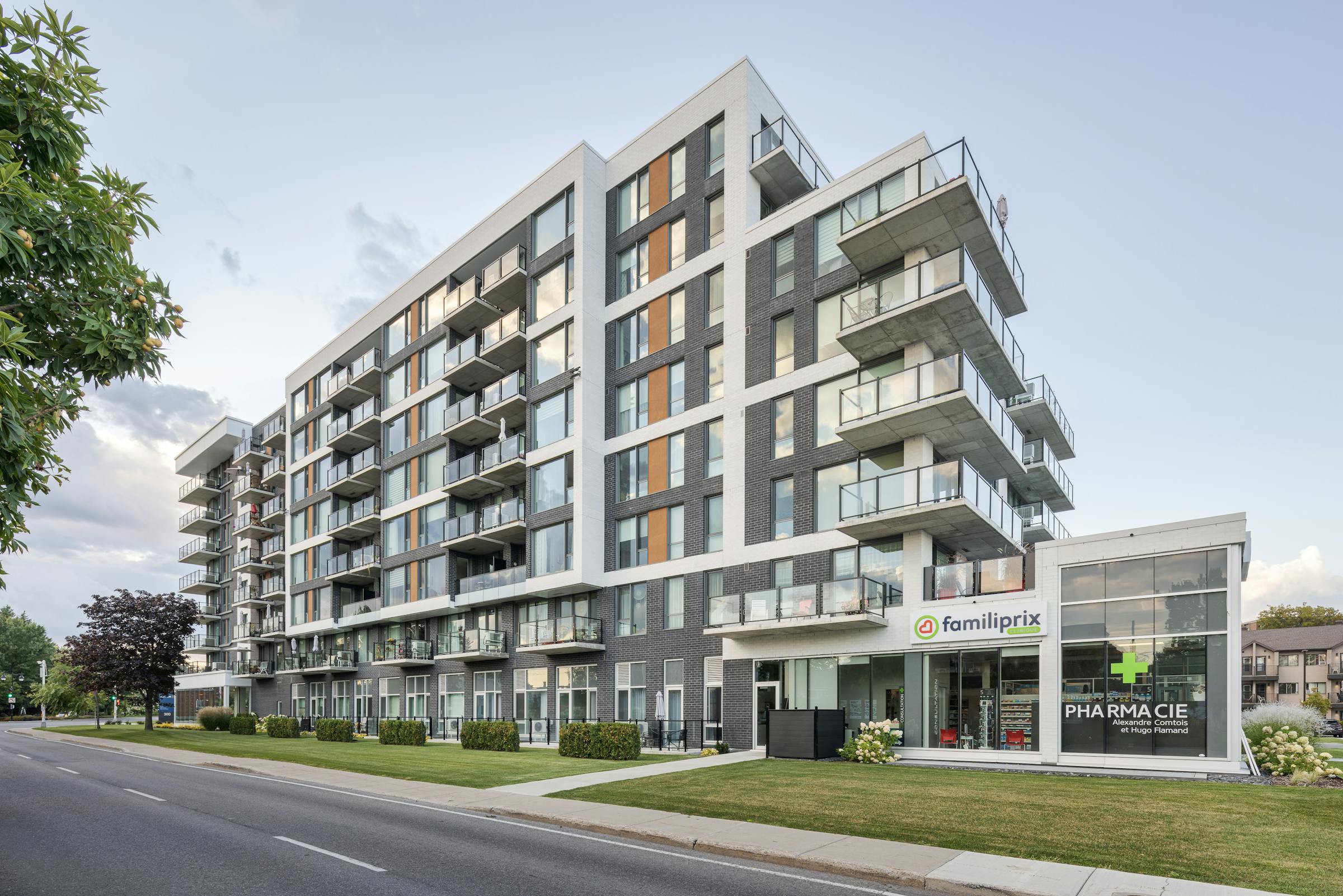Photograph of an 8-story building with refined architecture with commercial space on the ground floor.