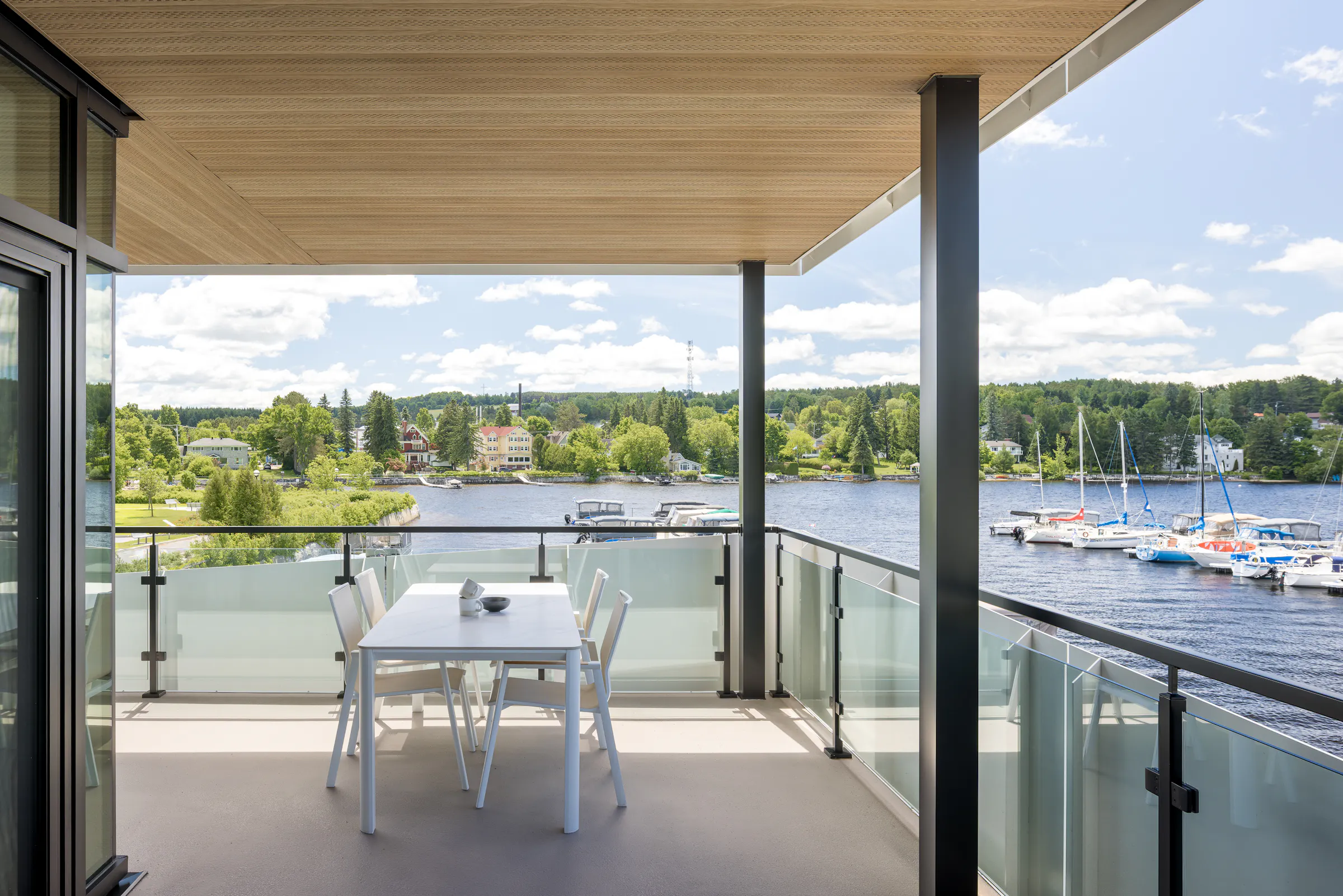 Photographie d'architecture d'une terrasse privée aménagée, cadrée sur la marina de Lac-Mégantic