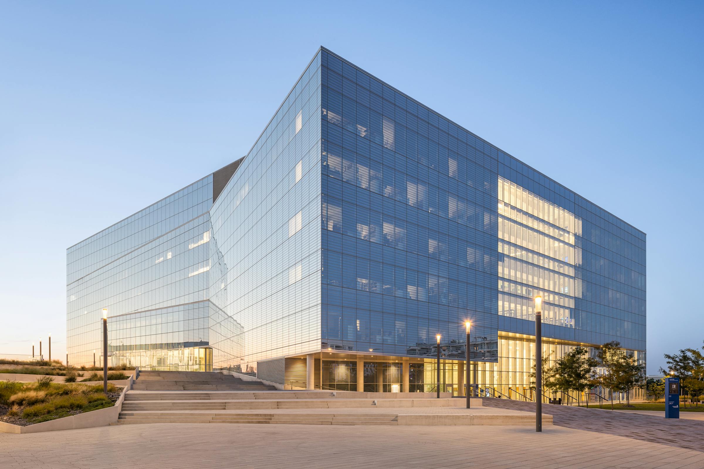 Pavilion of the University of Montreal, at night, which highlights the modern architecture of the glass surfaces.