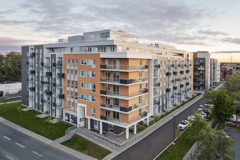 Architecture multi résidentiel au lever du soleil d'une bâtisse avec des volumes et matériaux interessants.
