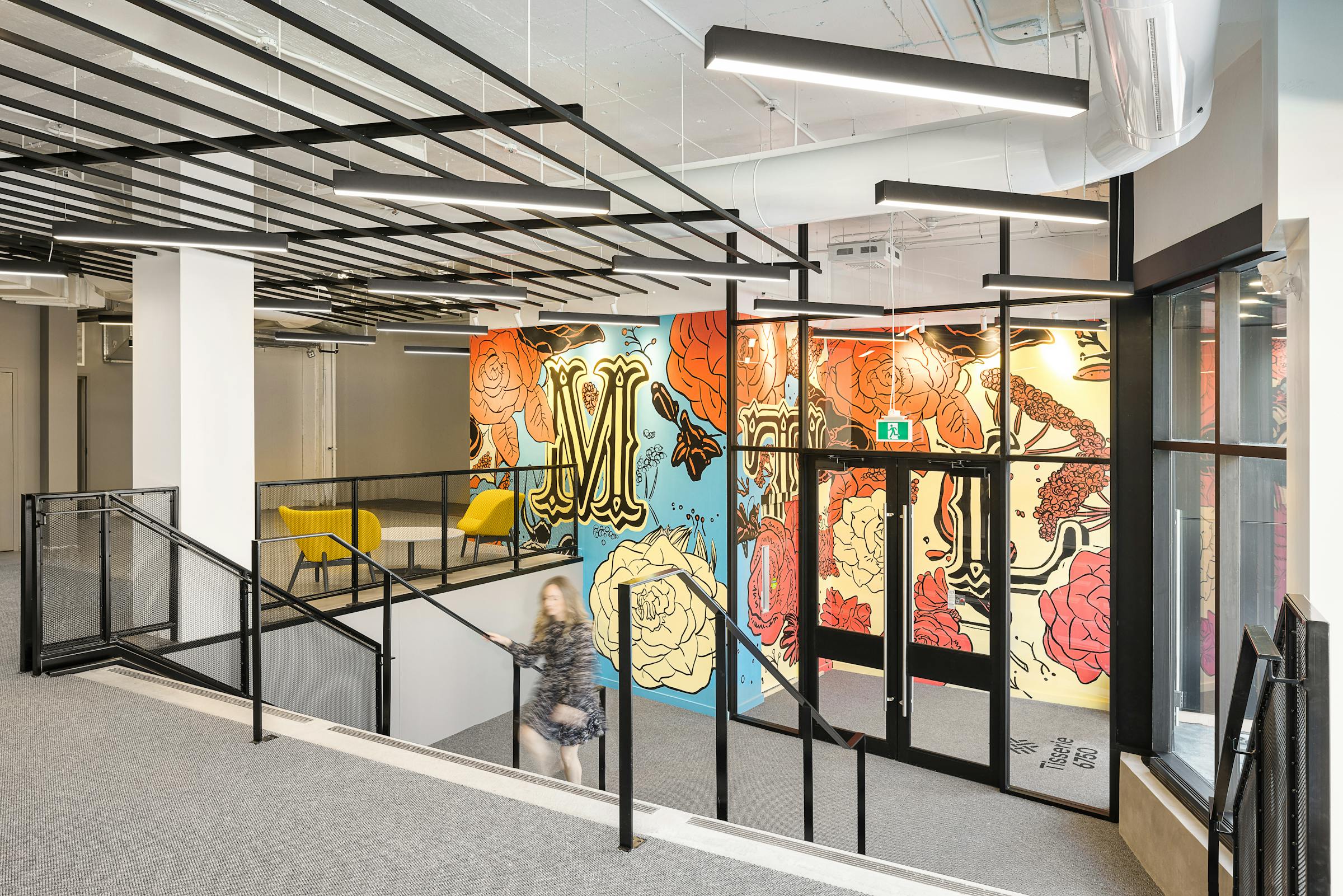 Escalier et murale architecturale avec une silhouette en mouvement.