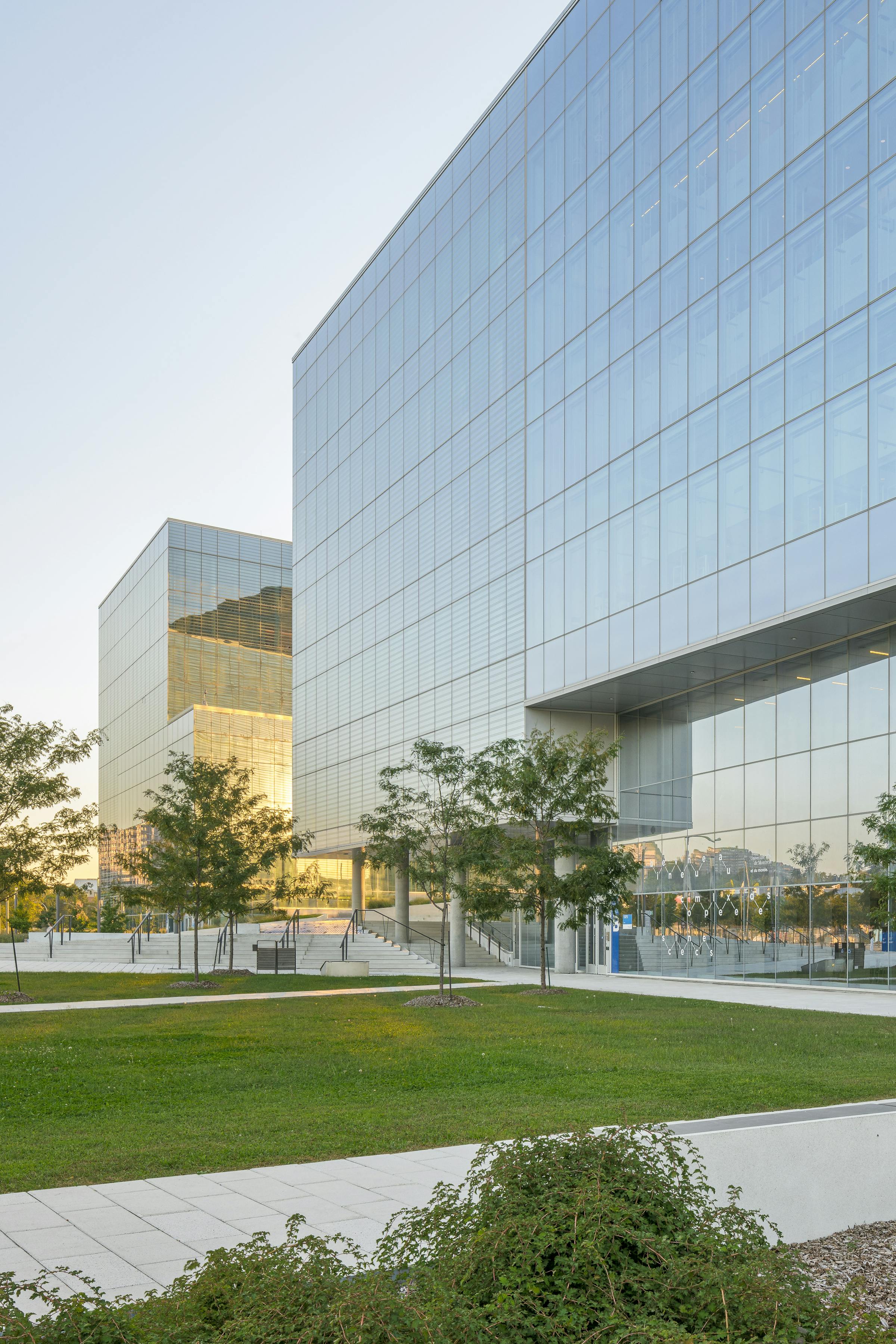 Architectural photograph of two glass buildings. We can see the sunset between the two.
