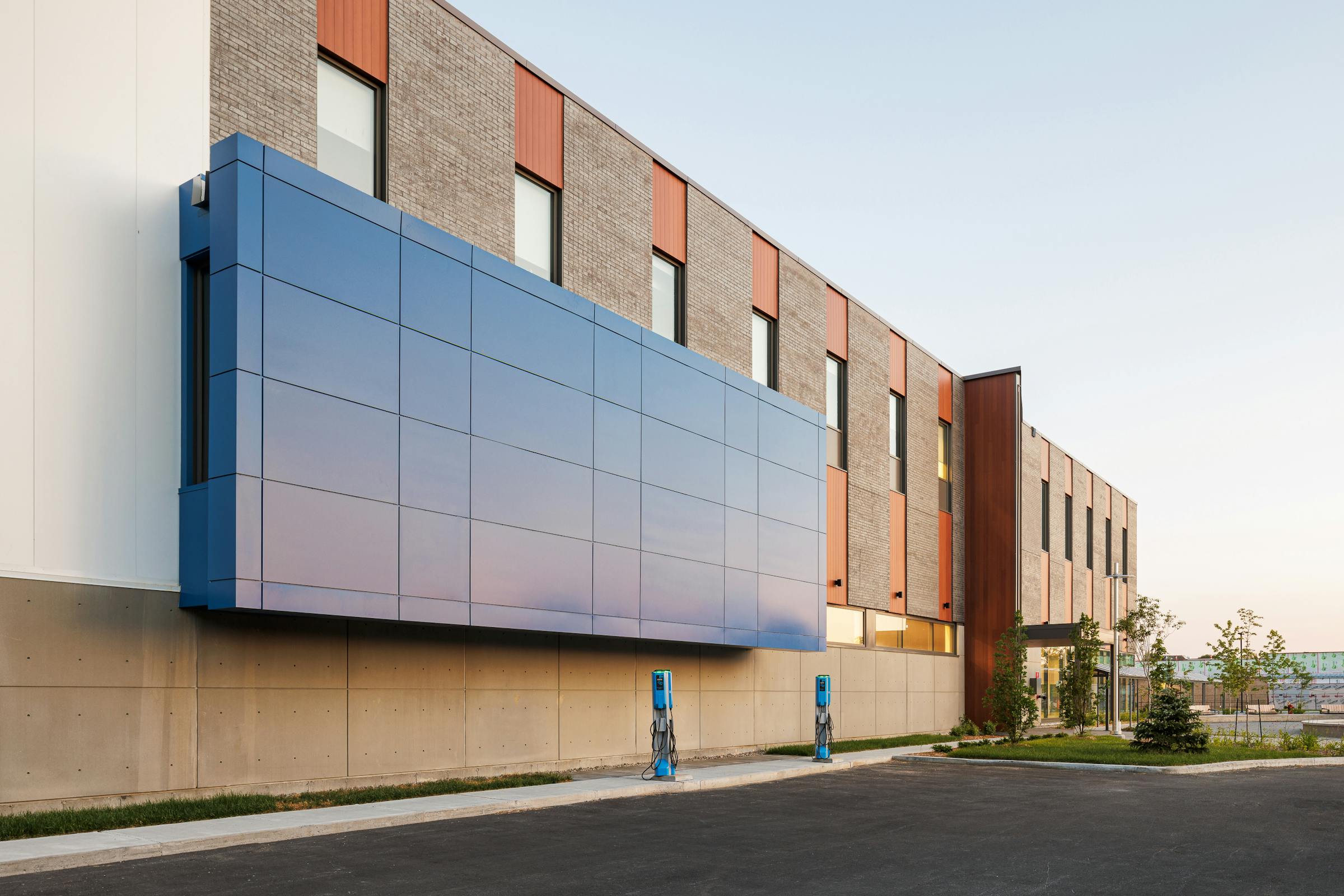 Photographie de la facade architecturale d'un complex sportif avec un volume bleu tres distinctif.
