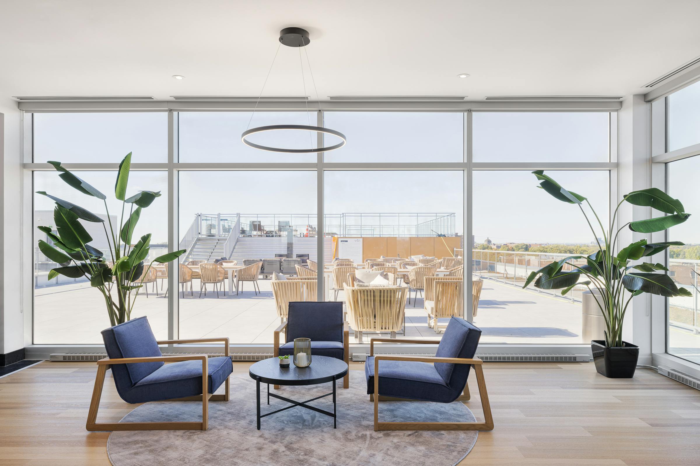 Photographie d'espaces intérieur avec du mobilier contemporain et une grande bais vitrée avec vue sur la terrasse.