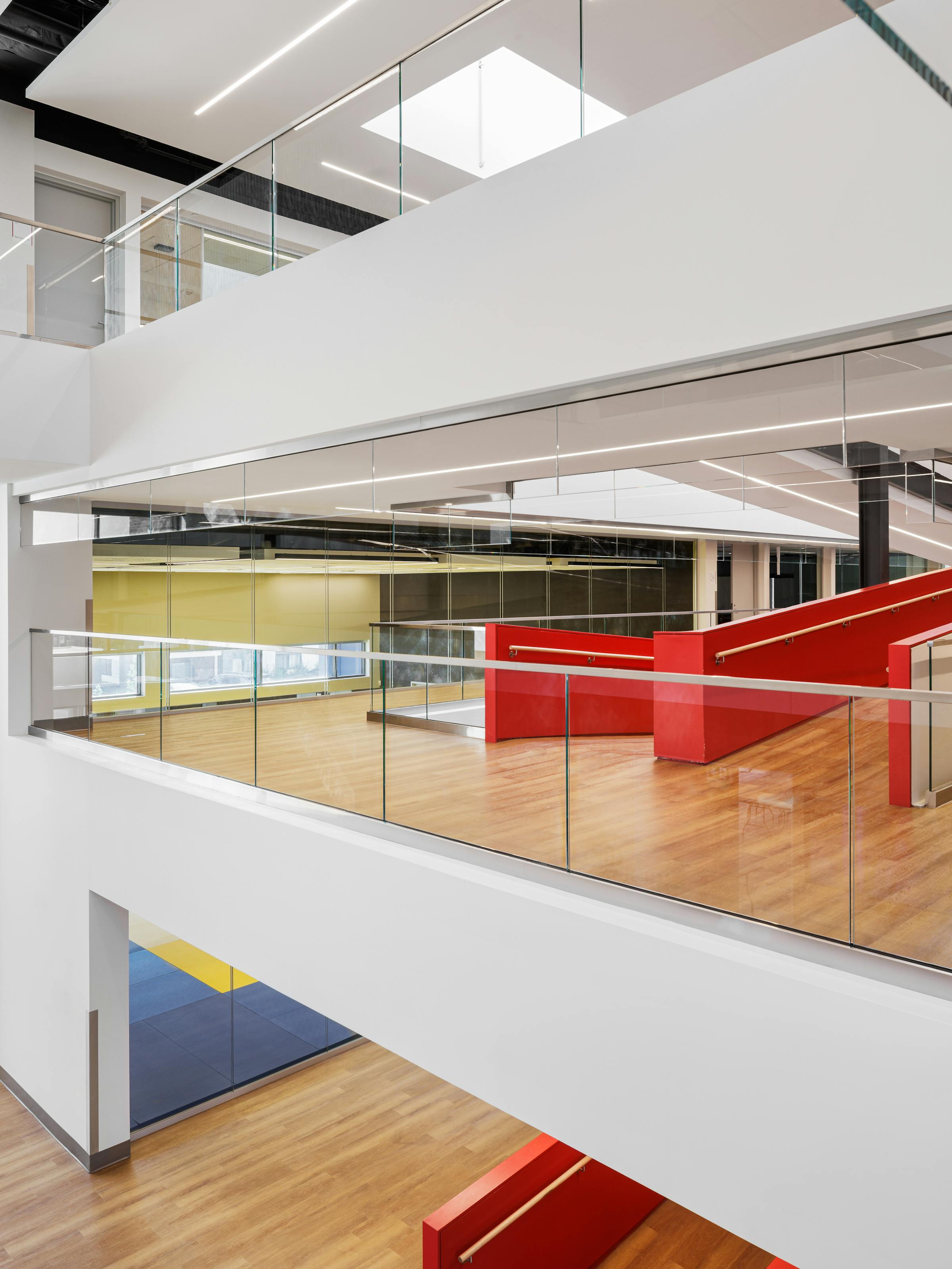 Photographie intérieure en angle des trois étages de l'atrium dans un bâtiment modern et design.