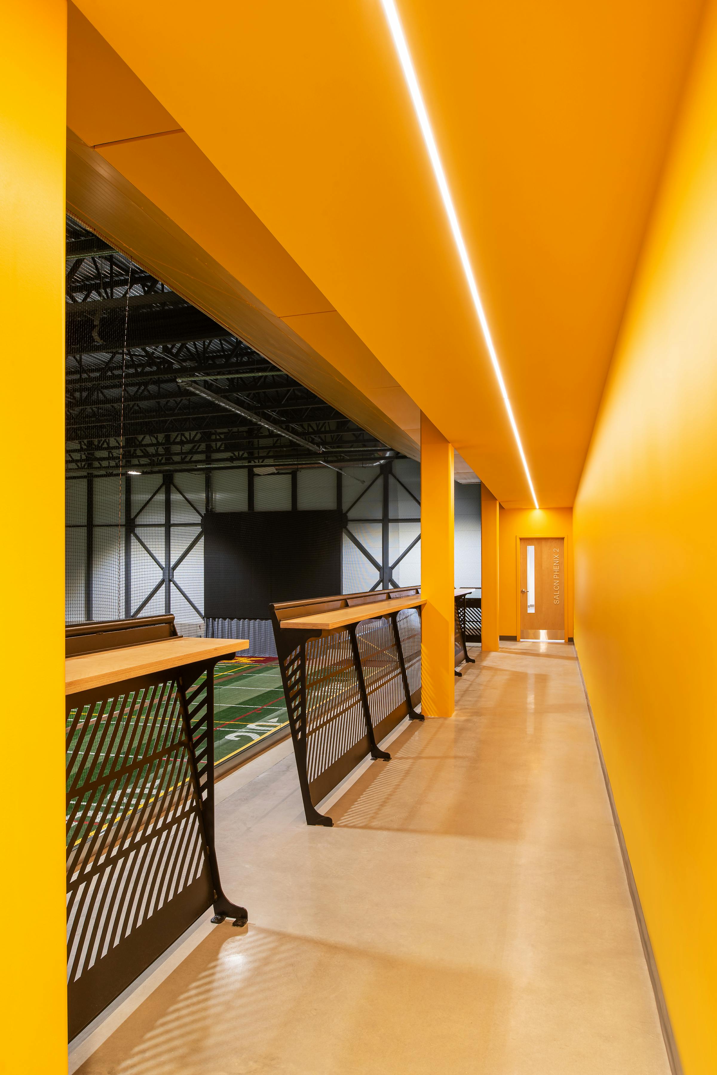 La galerie de l'estrade jaune devant un surface de jeu synthétique.