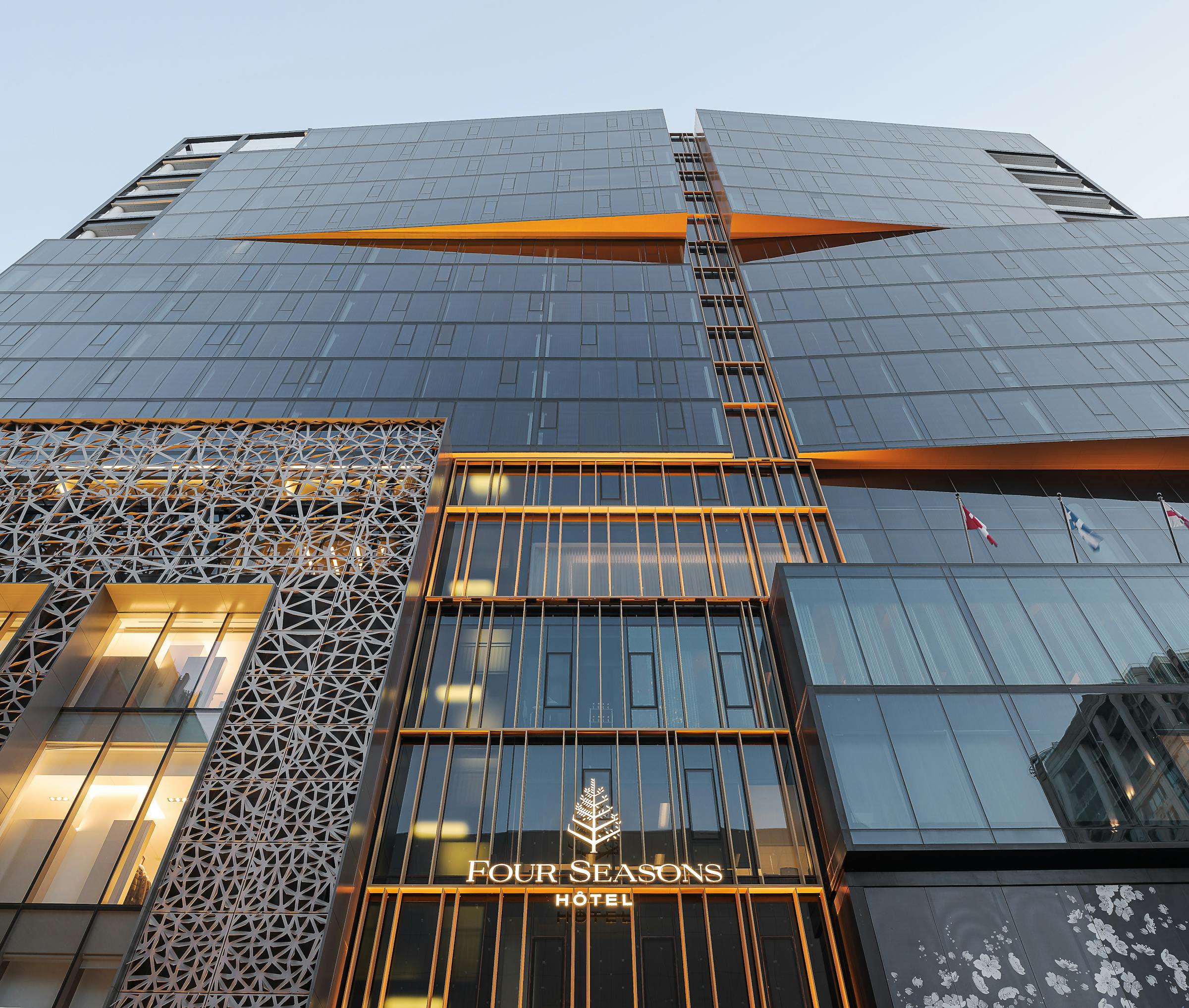 Low angle architectural photography of the architectural facade of a hotel in downtown Montreal at blue hour.