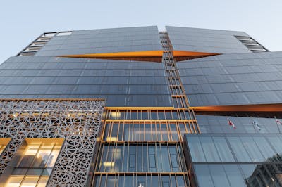 Photographie d'architecture en contre-plongé de la facade architecturale d'un hôtel au centre ville de Montreal à l'heure bleue.