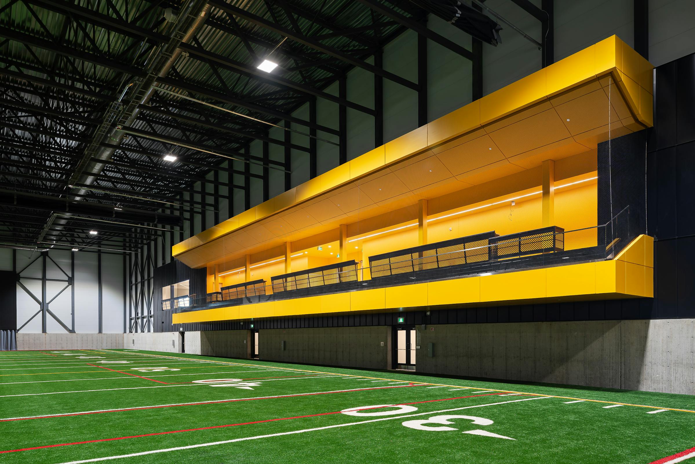 Une estrade jaune dans une salle de sport intérieur. Un beau contraste de couleur entre le jaune de l'estrade et le vert de la surface.