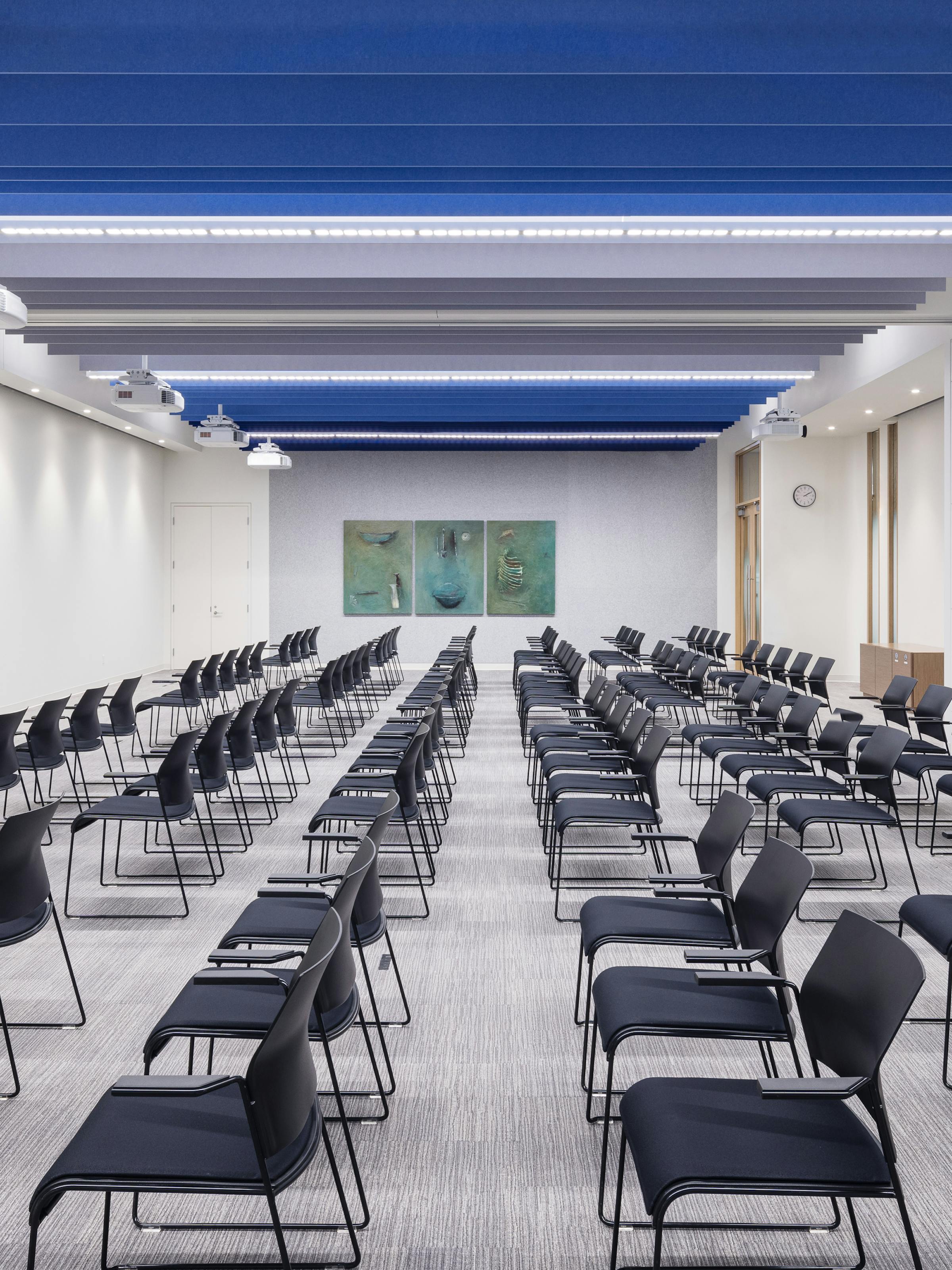 Interior design of a conference room with blue acoustic panels on the ceiling.