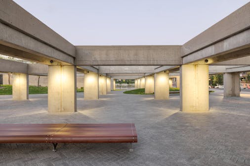 Public square with brutalist architectural elements and innovative public lighting.