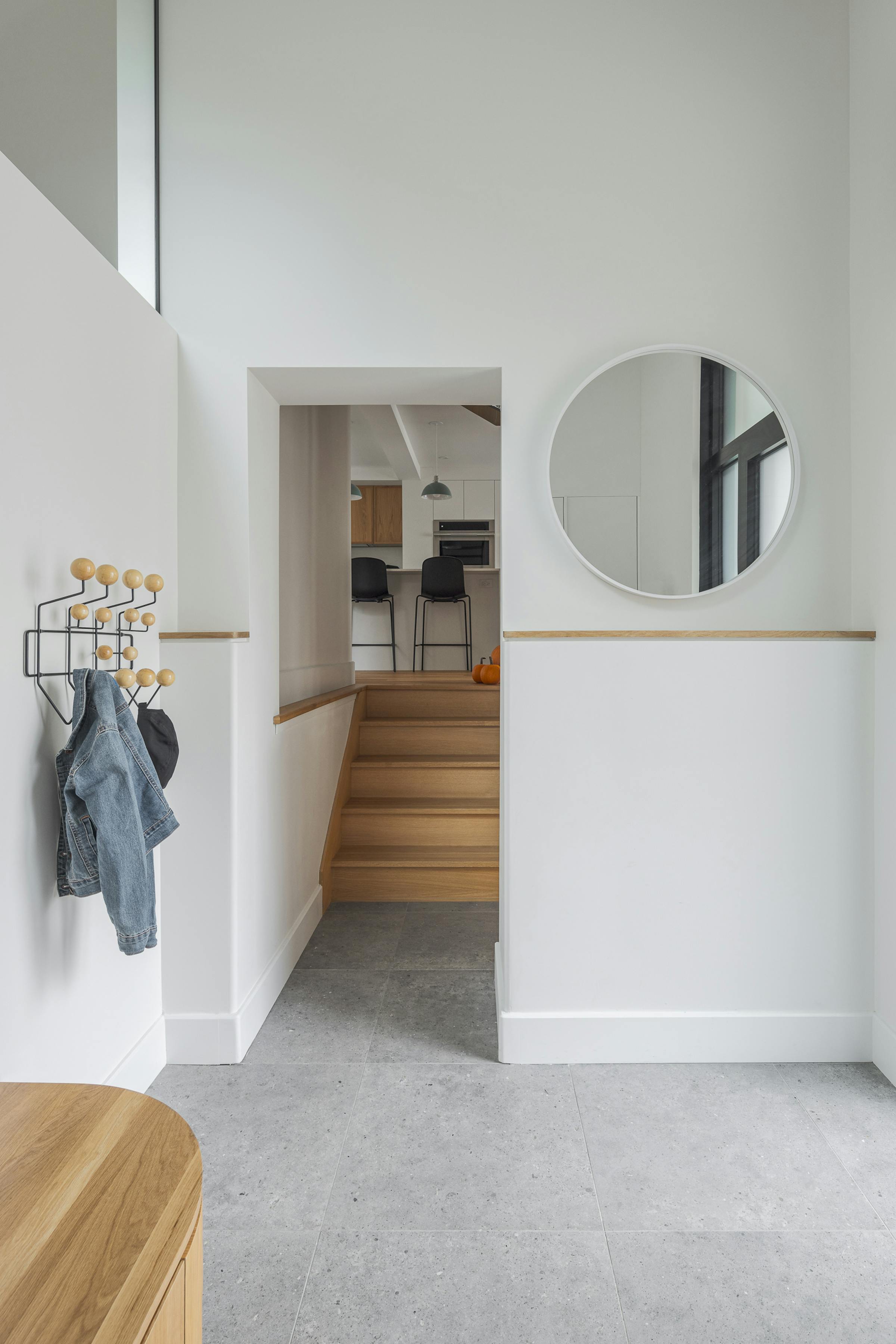 Photographie du sas d'entrée en double hauteur dans une maison montréalaise moderne et lumineuse.
