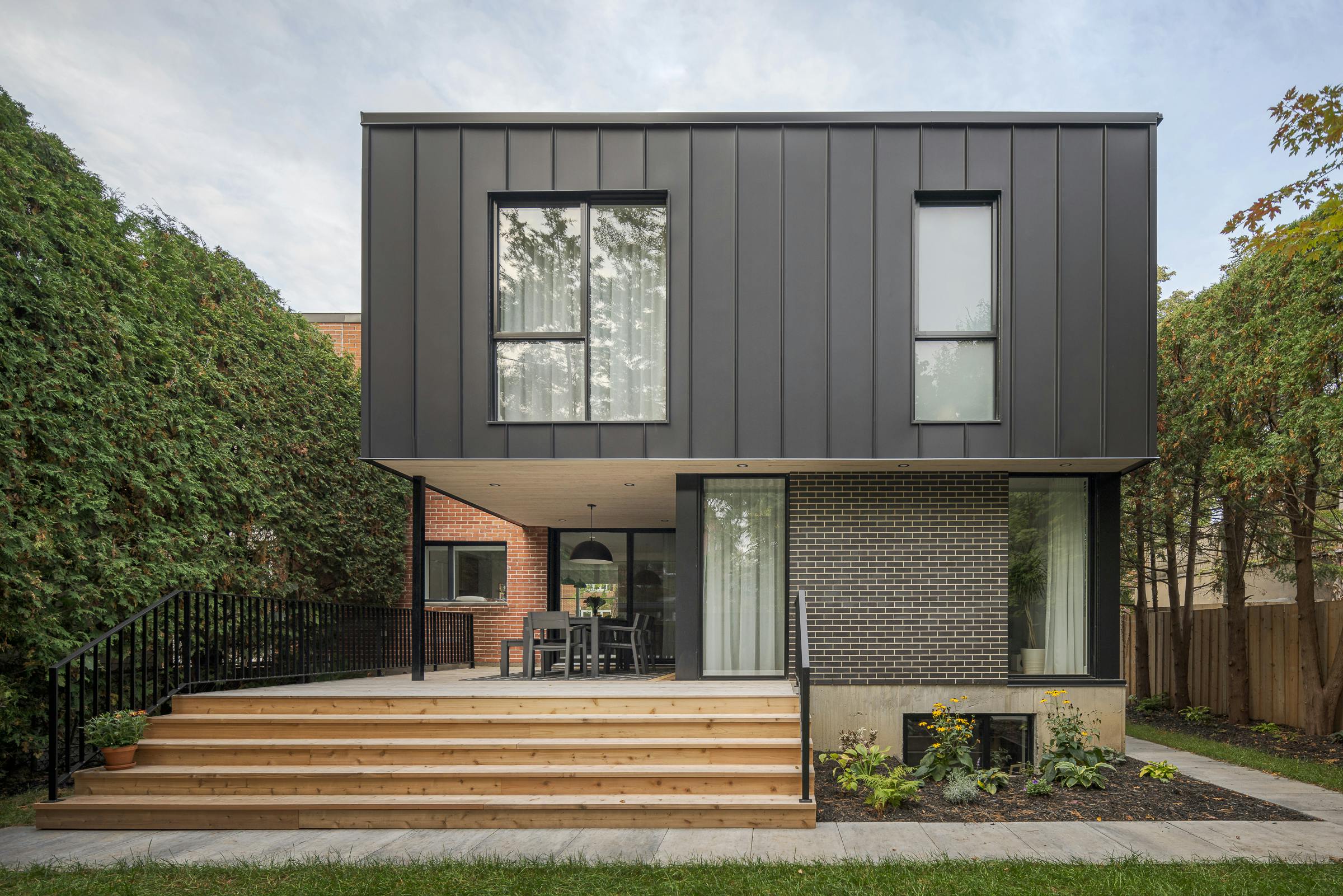 Façade arrière d'une propriété unifamiliale dans Ahuntsic-Cartierville montrant l'agrandissement et la terrasse couverte.