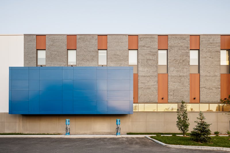 Vue à un point de fuite de l'architecture extérieur d'un bâtiment avec un volume bleu tres distinctif.