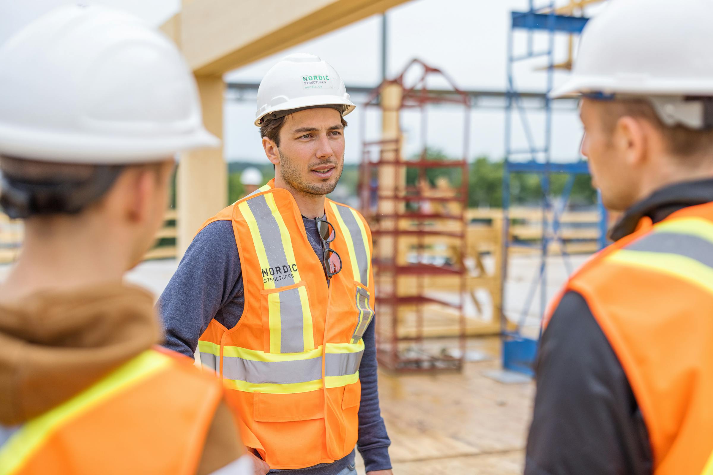 Meeting between 3 employees on a construction site.