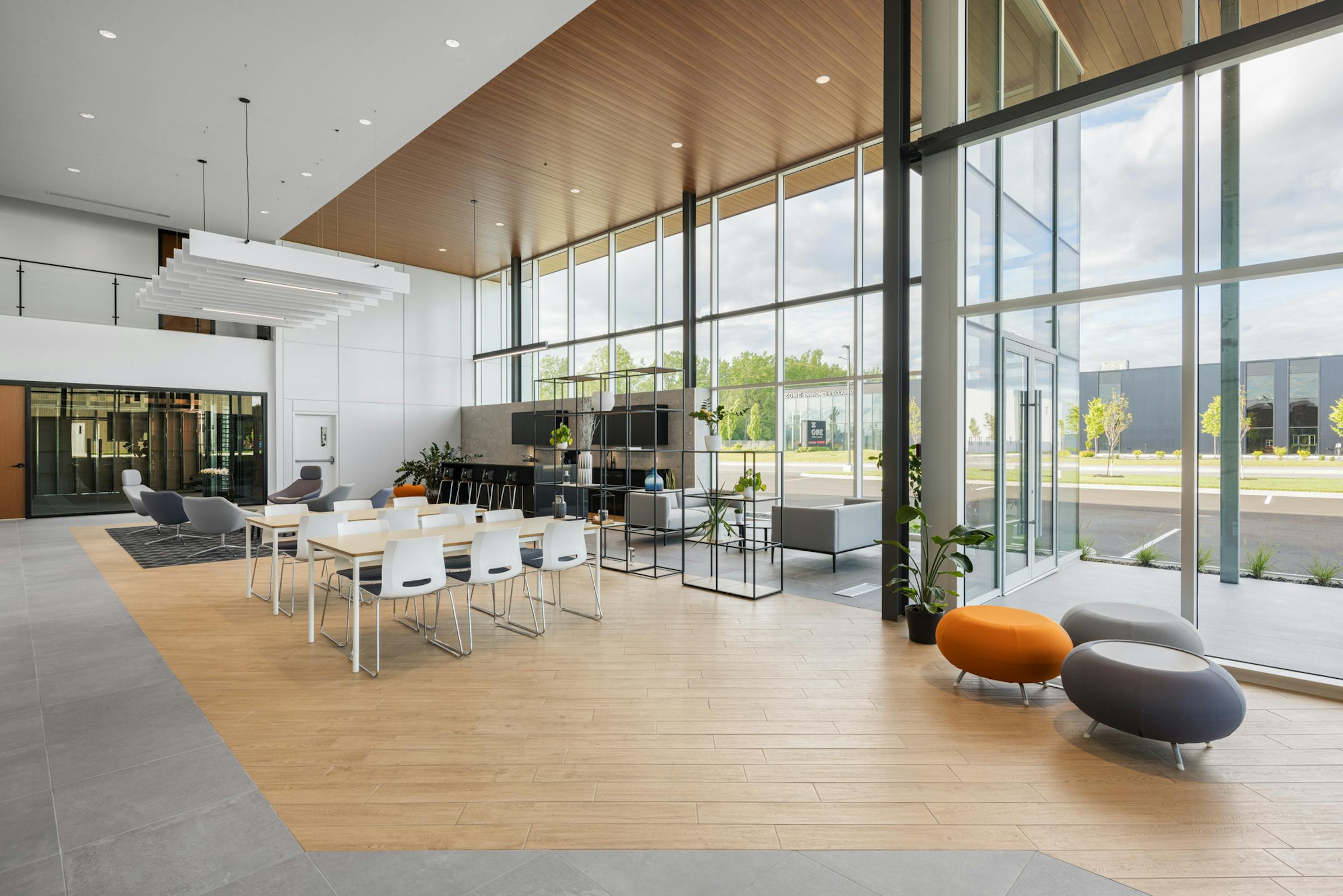 Interior space of a commercial building in Blainville with dining table, lounge area. We see the different textures used.