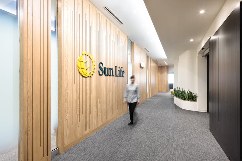 Photographie de l'architecture d'un couloir dans des bureaux corporatifs d'une banque canadienne avec une silhouette en mouvement.