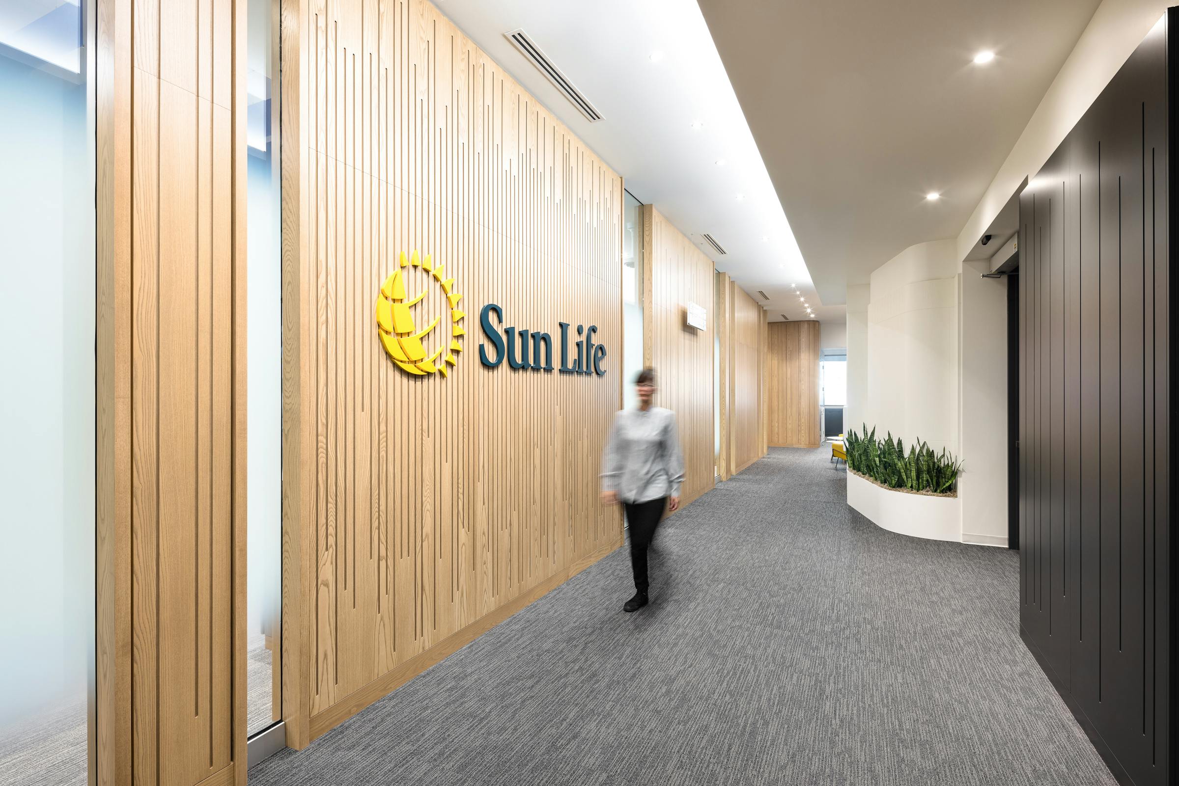 Photograph of the architecture of a corridor in the corporate offices of a Canadian bank with a moving silhouette.