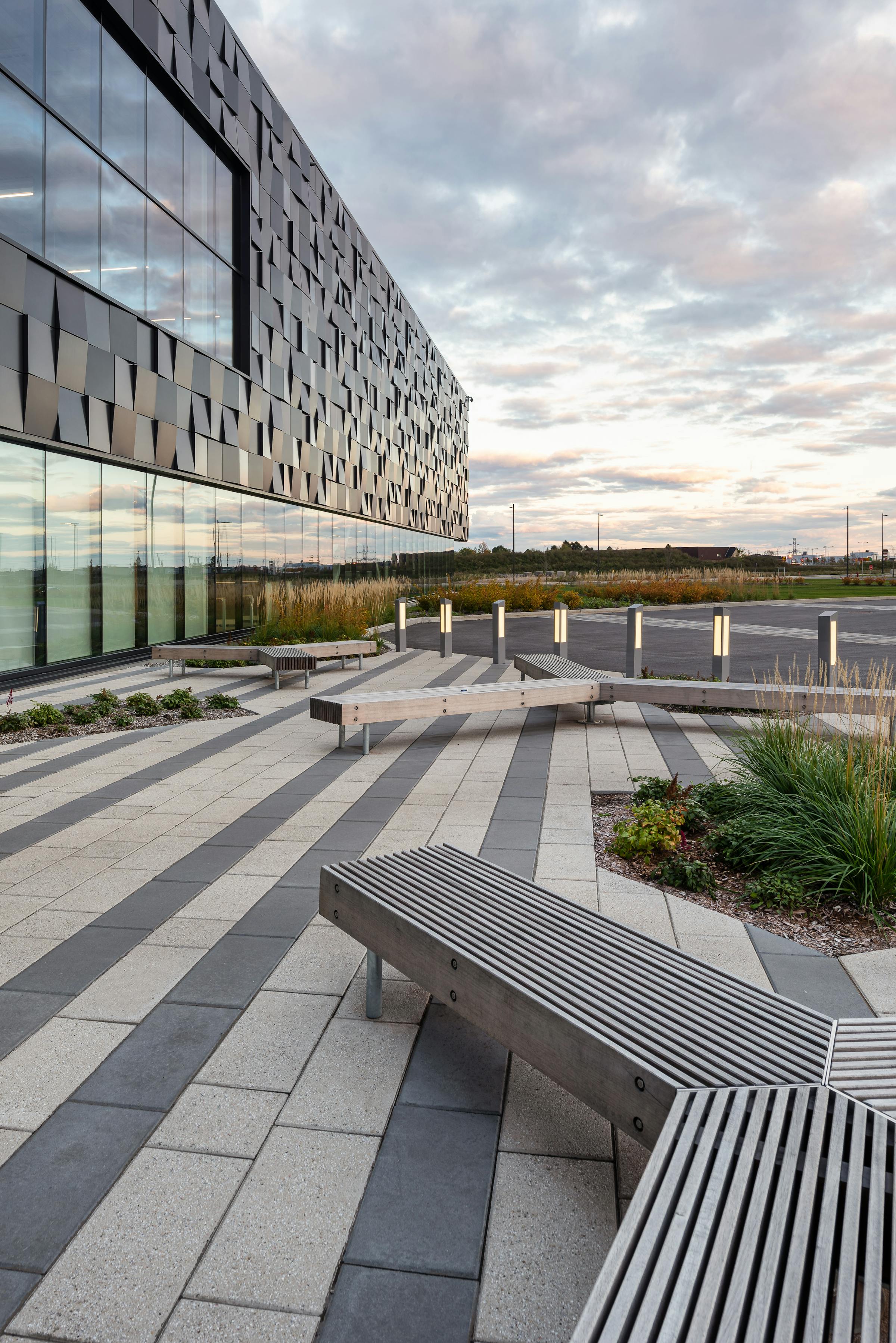 Photograph of street furniture in front of a building with original architecture.