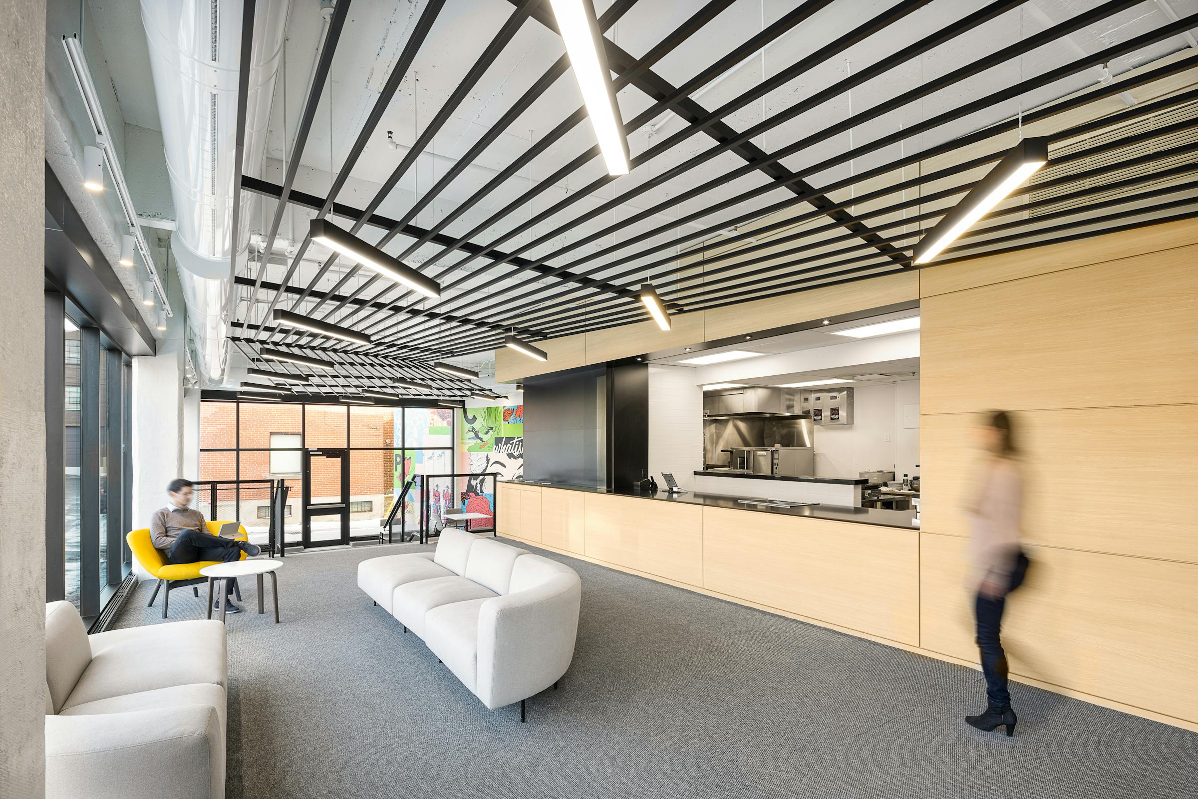 Silhouette en mouvement devant un comptoir de café dans le lobby d'un edifice commercial.