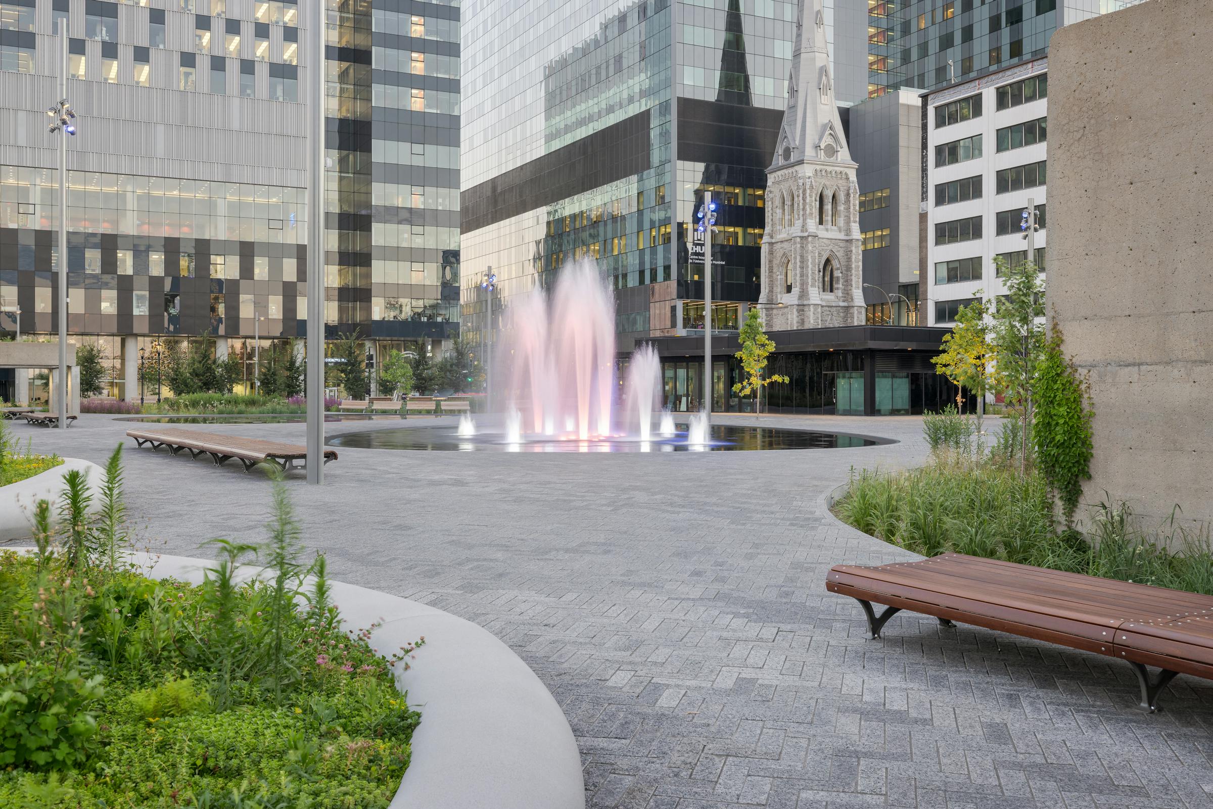 Fontaine sur une place publique dans un environnement architectural de ville.