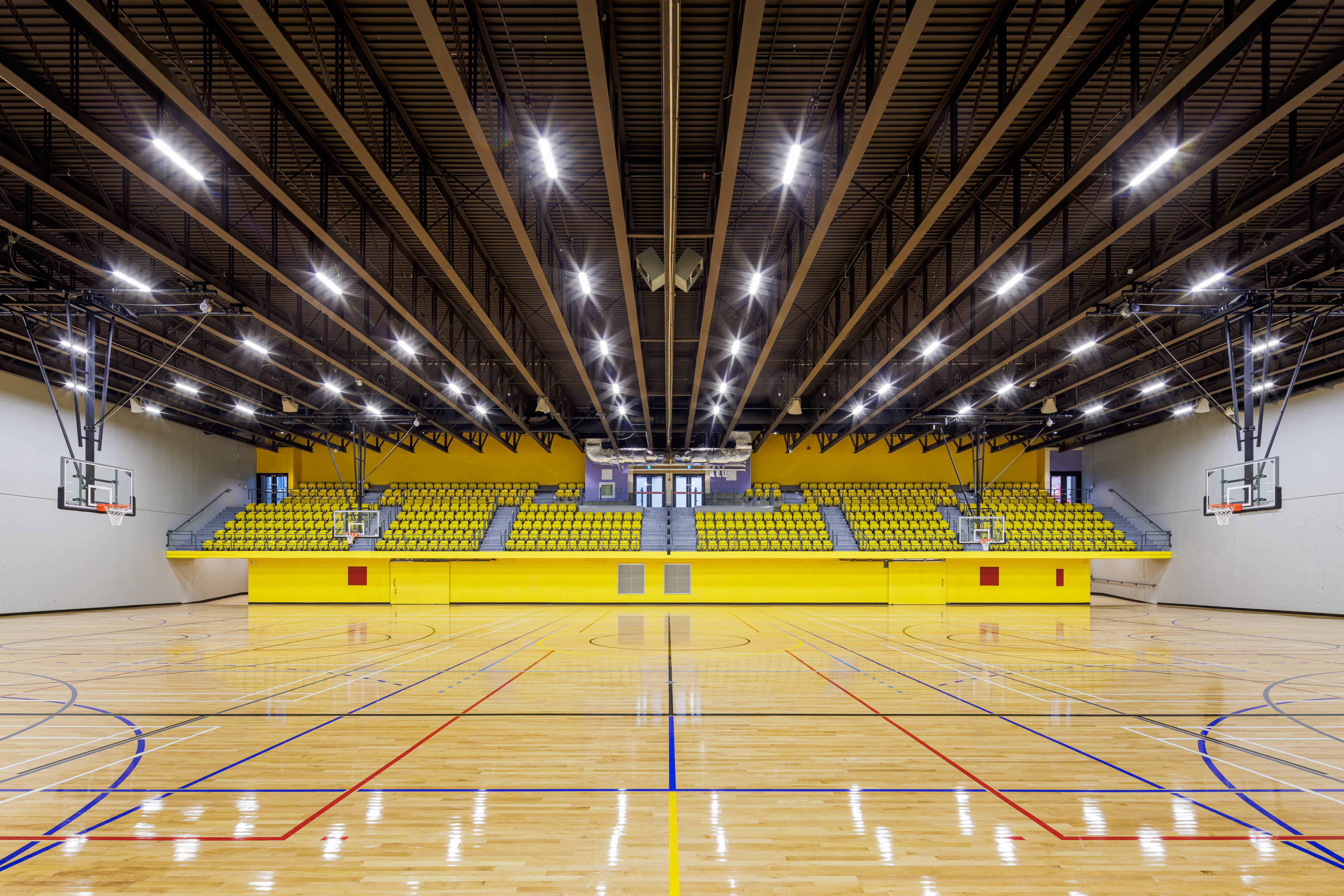 Architectural photograph of the double gymnasium at the Claude-Robillard Sports Complex, exposed steel structure, Montreal.