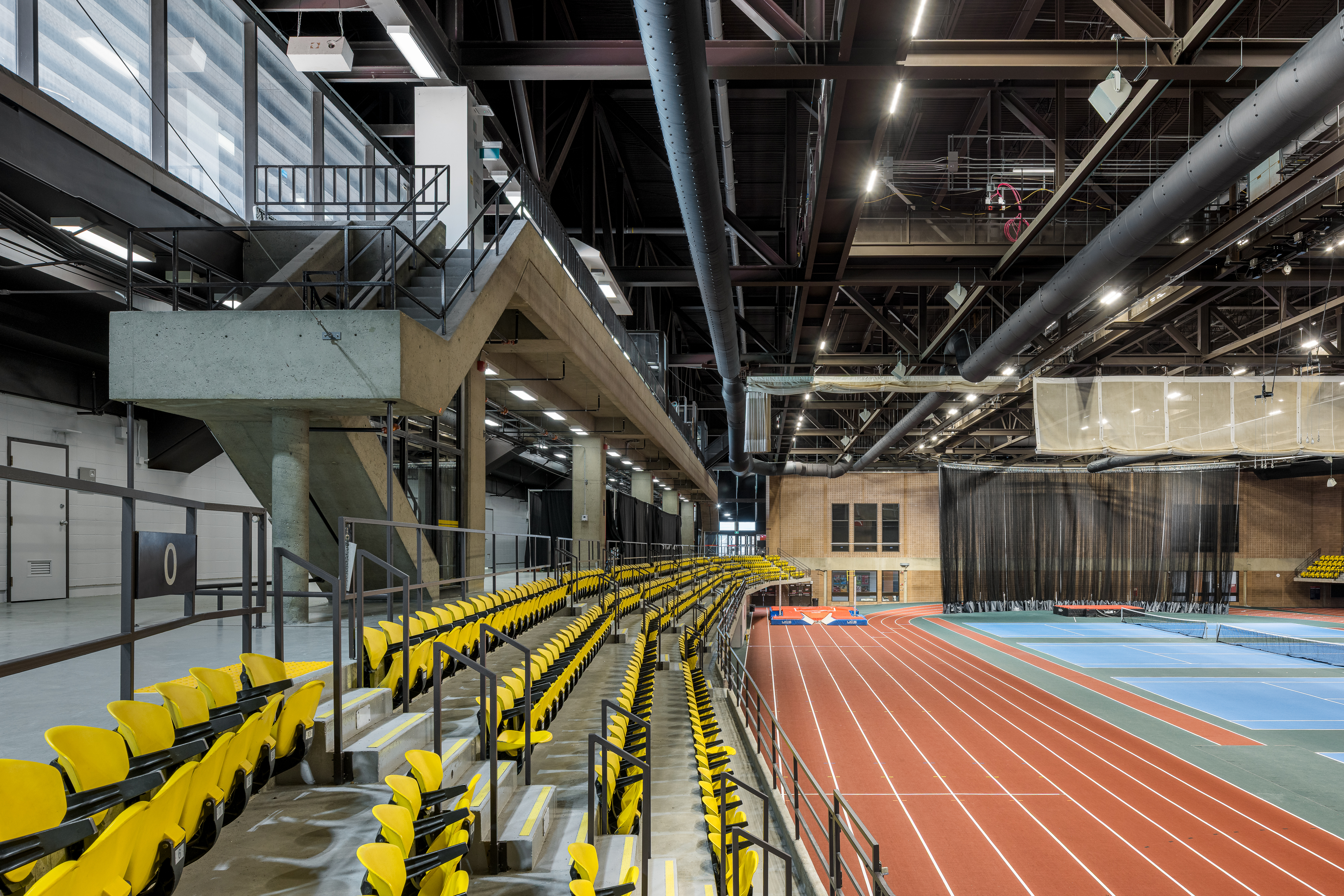 Architectural photography of the steel structure and stands of the sports hall, natural overhead lighting.