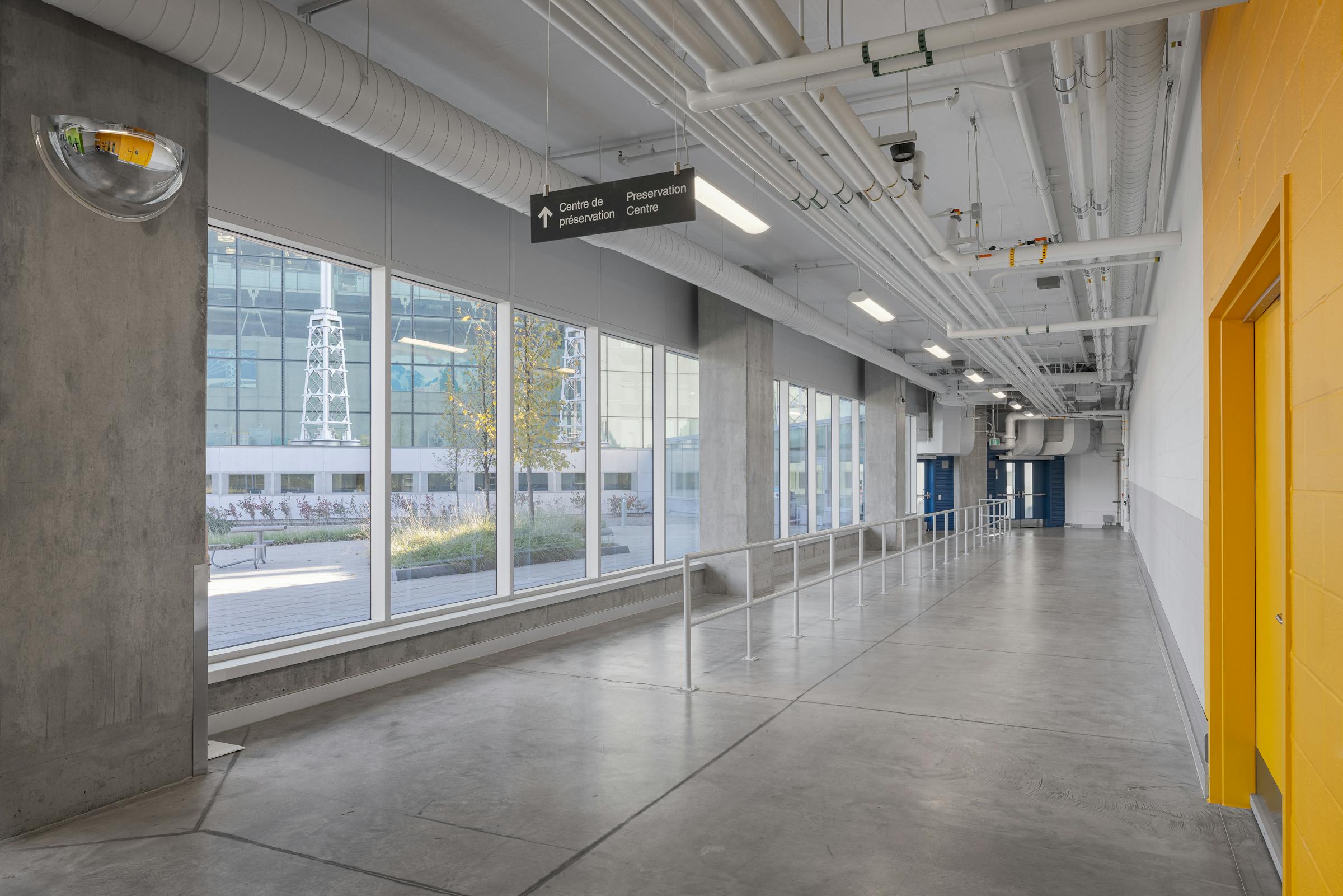 Passage vitré entre les différentes sections du bâtiment, favorisant la connexion des espaces.