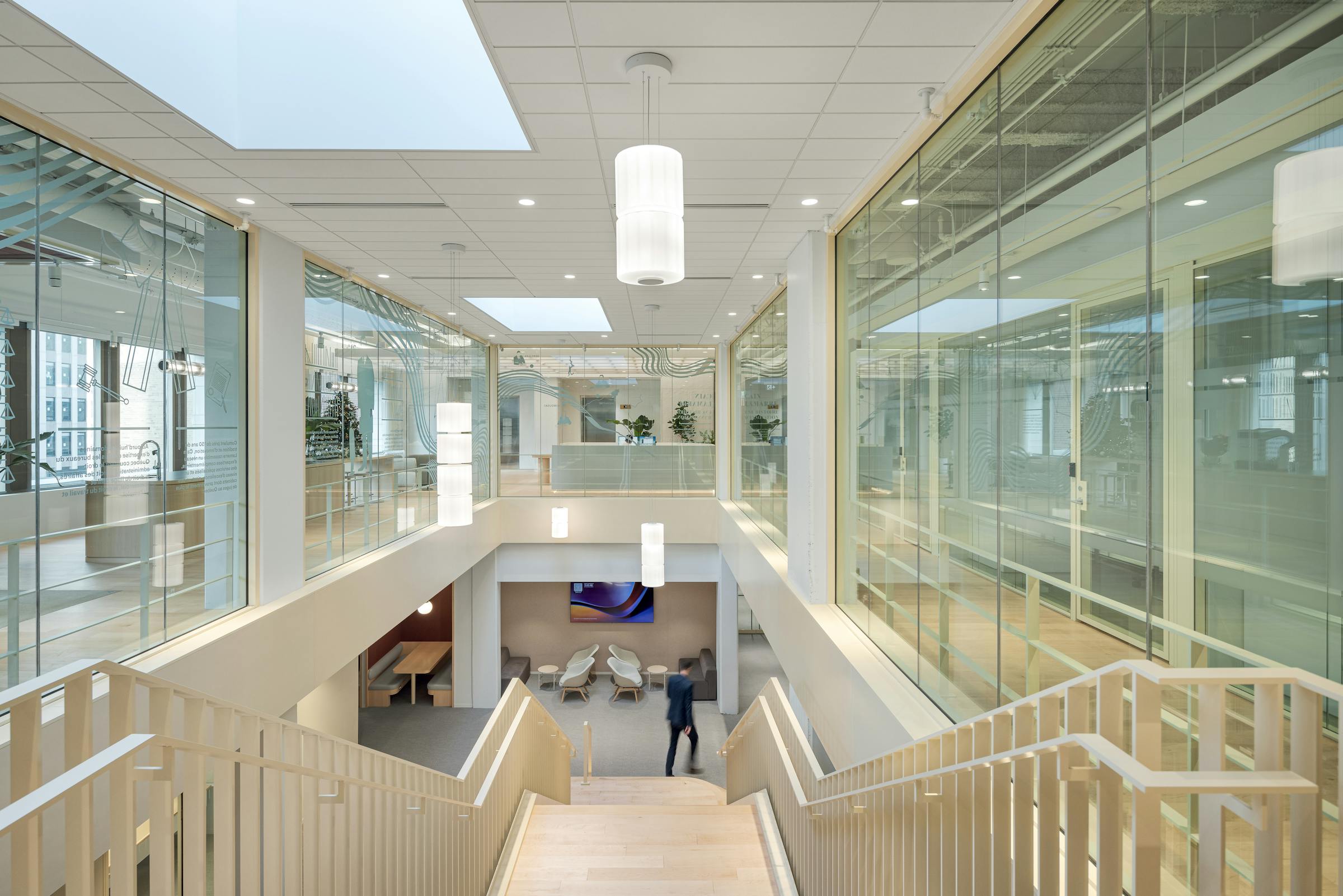 Élégance et fonctionnalité : un escalier architectural en bois flottant dans un atrium lumineux.