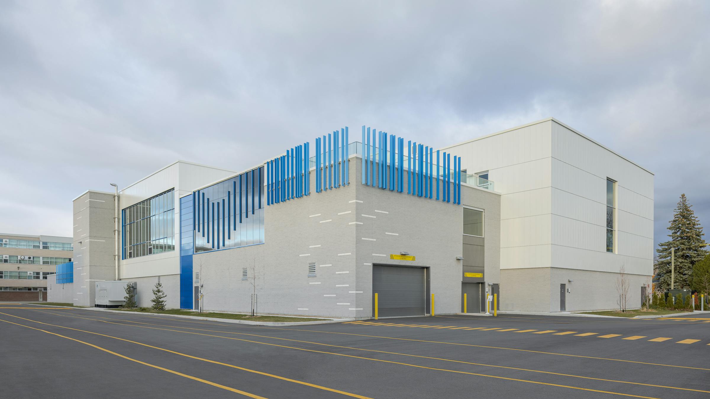 L’école Jean-Piaget photographiée en lumière naturelle, où les jeux de couleurs reflètent la mission inclusive du milieu scolaire.