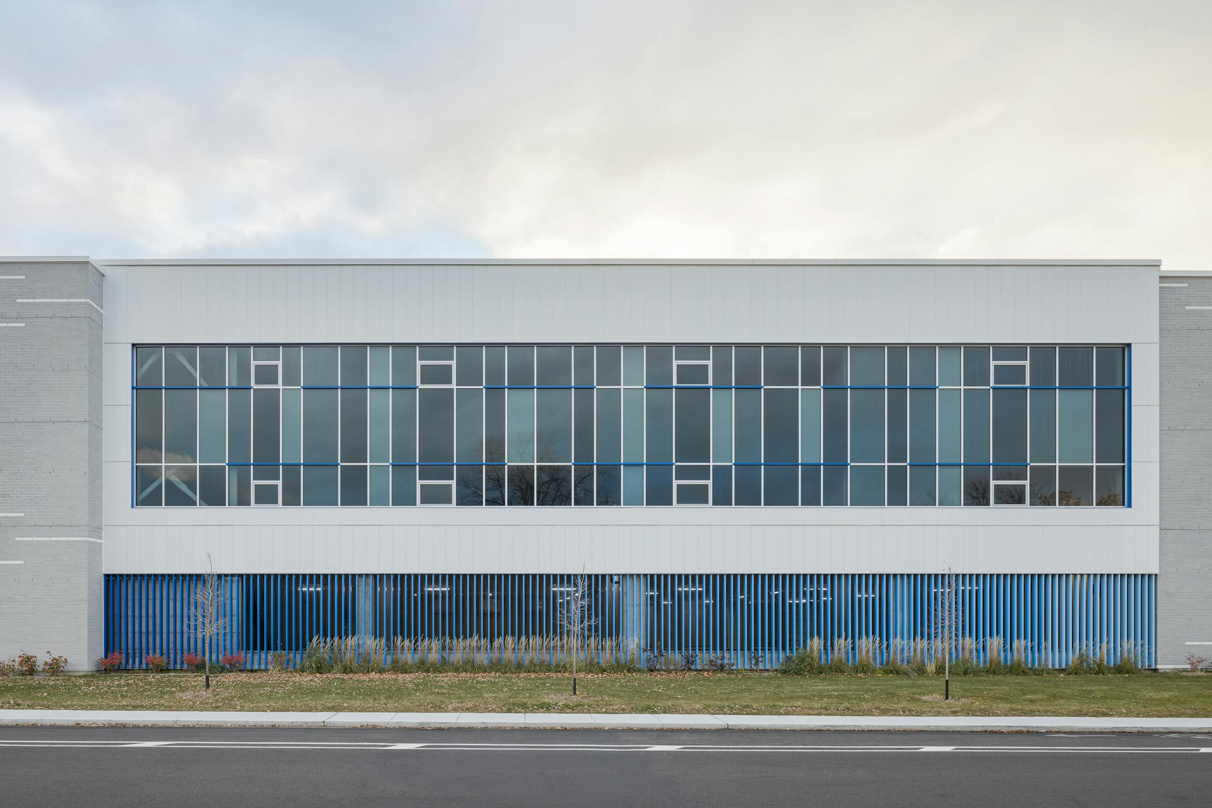 École spécialisée au design distinctif, mise en valeur par une façade rythmée de panneaux bleu Québec et de zones vitrées.