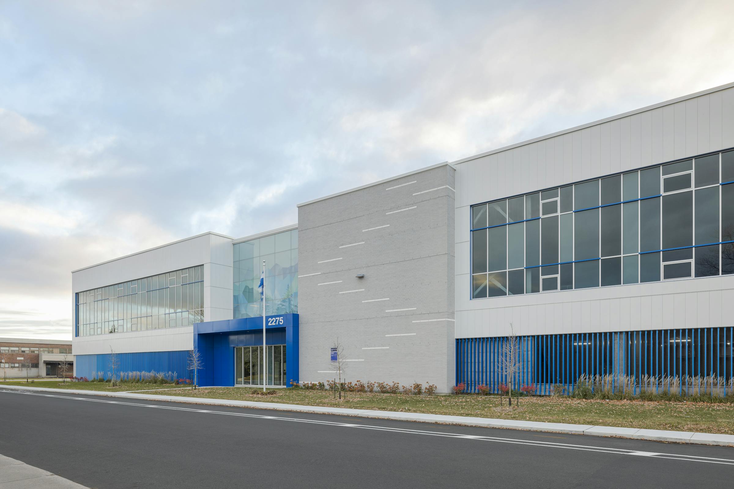 Façade colorée de l’école Jean-Piaget, où les accents bleu Québec dynamisent l’architecture scolaire contemporaine.