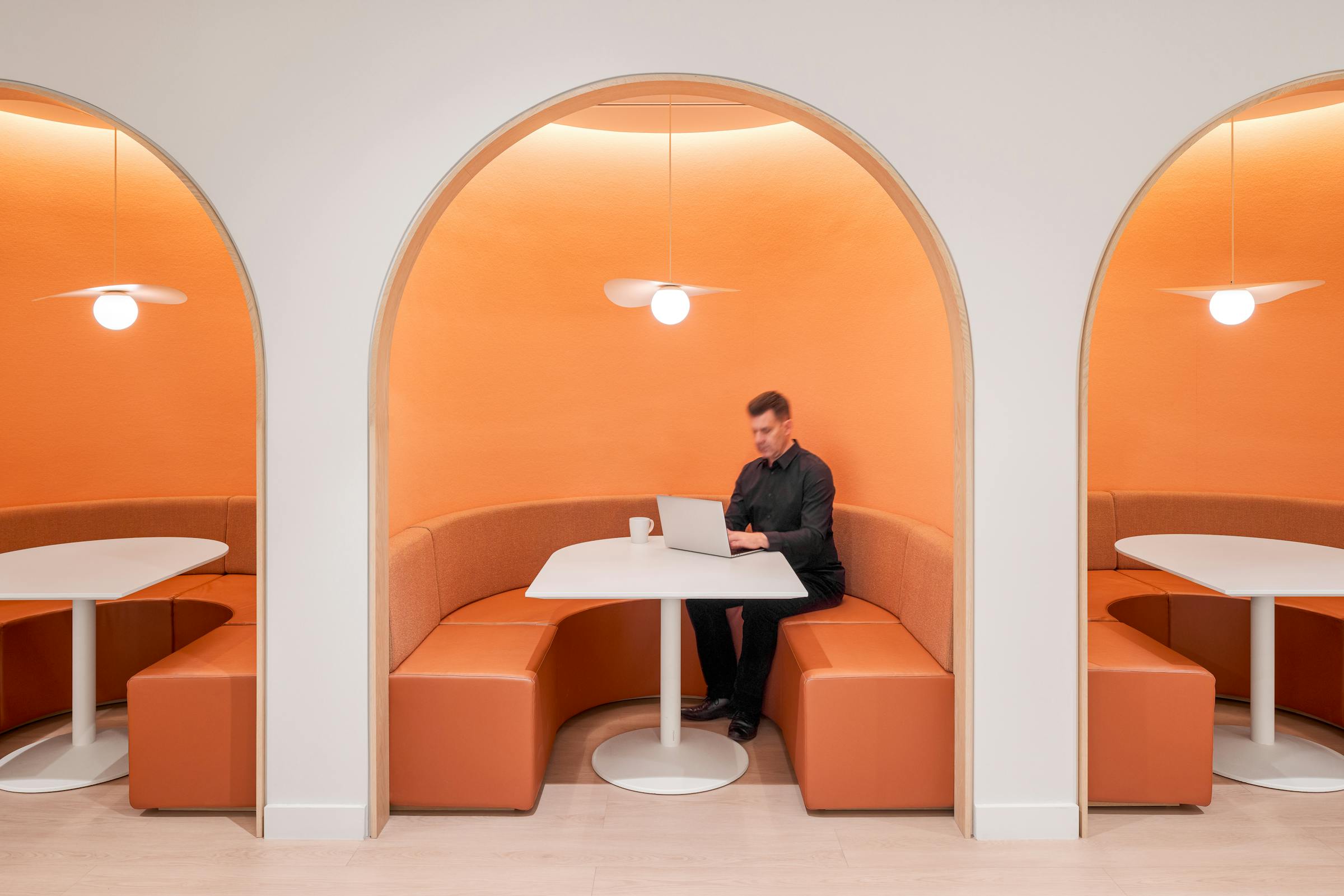 Close-up of orange alcoves housing dining tables.