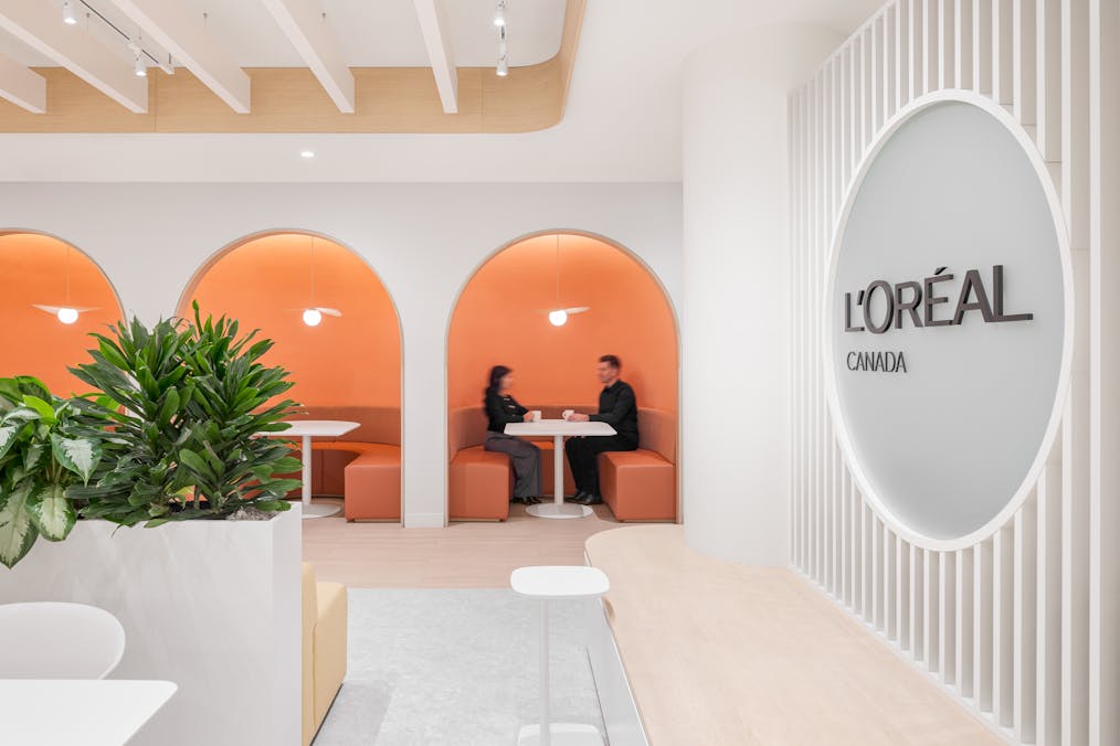 Espace de restauration avec des alcoves au design coloré et au mobilier modern. On voit le logo de L'Oréal.