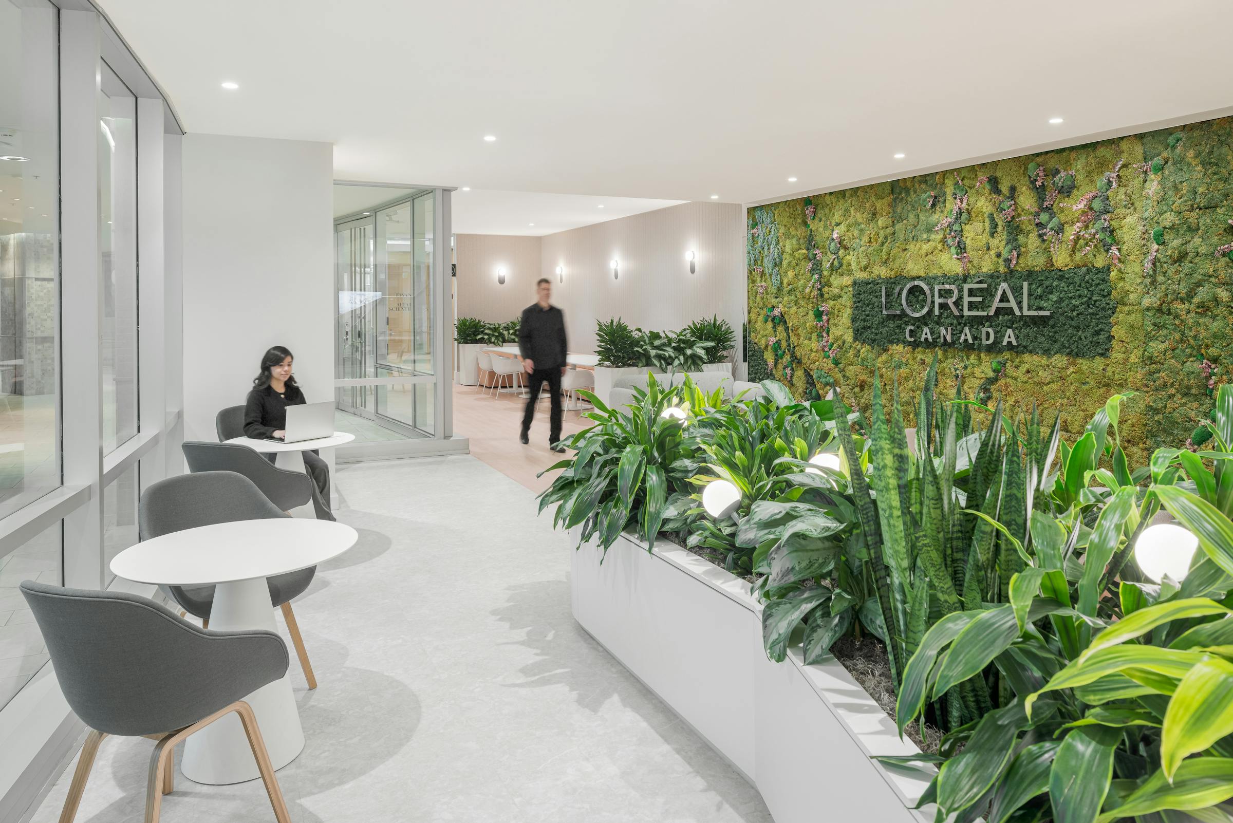 Green wall with the L'Oréal logo in a space where biophilia is very present.