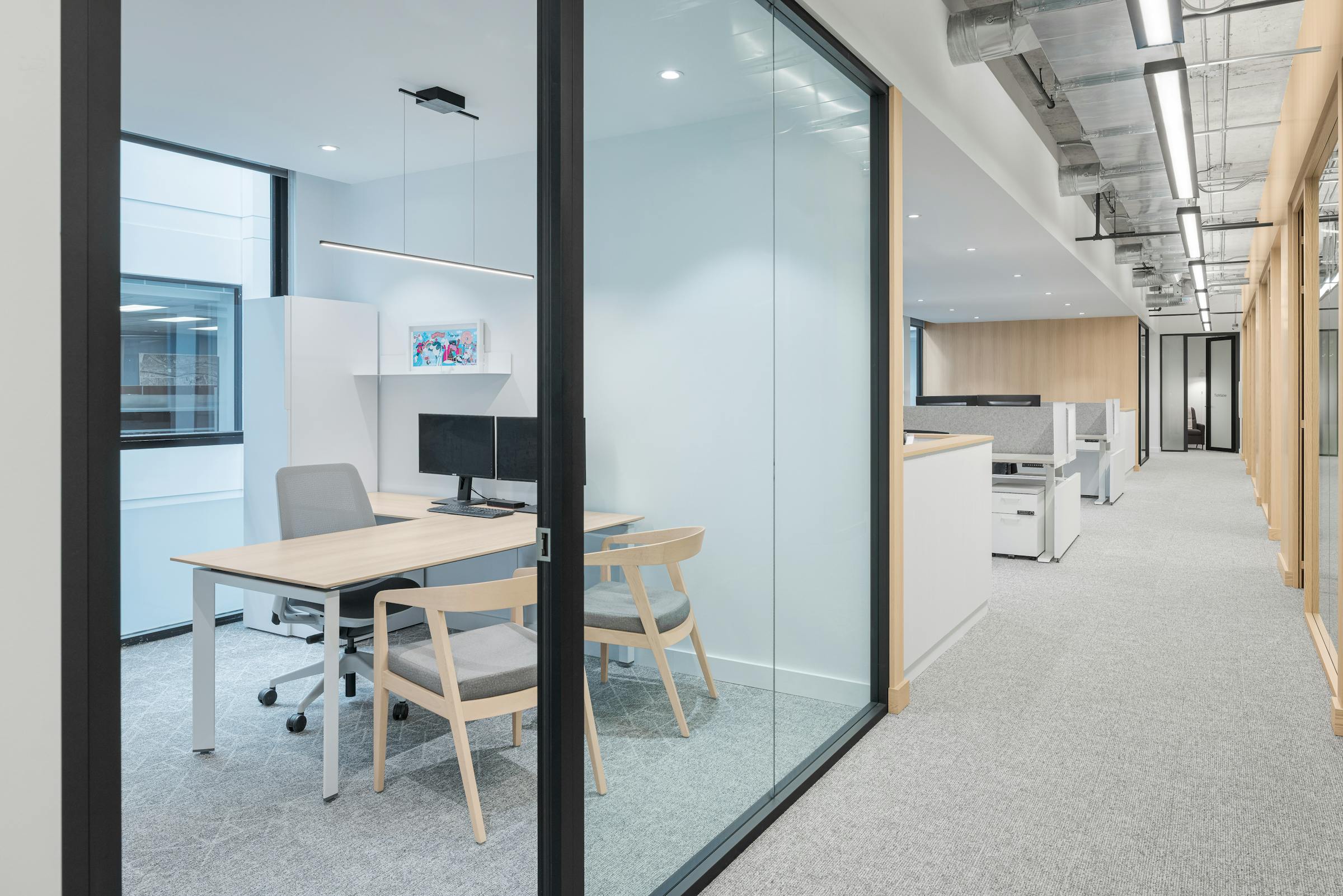 Mur architecturales en verre dans des espace de travail collaboratif au design alliant bois et matériaux moderne.