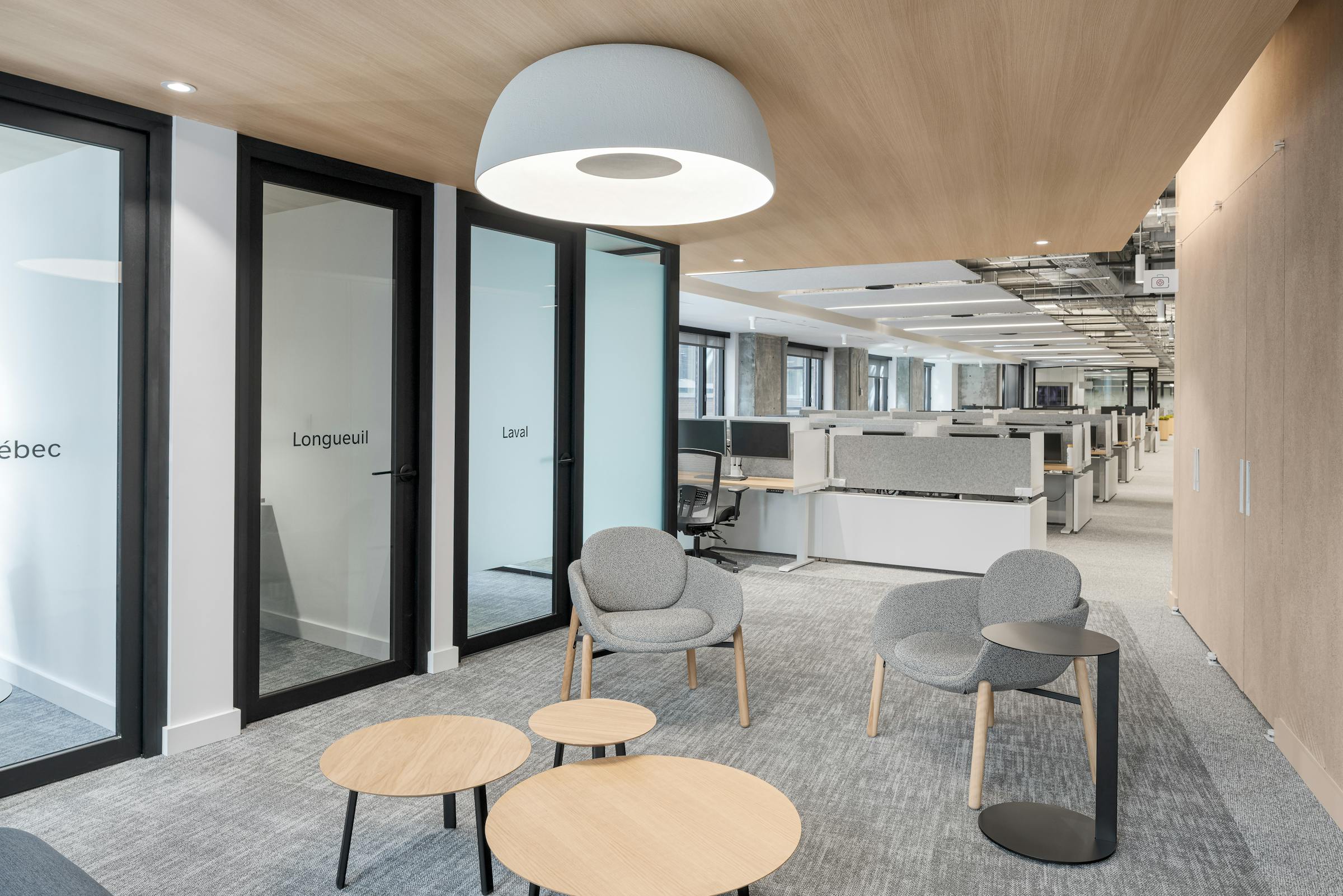 Architecture de bureau moderne : murs de verre structuraux, chaises ergonomiques design et intégration de plantes vertes.