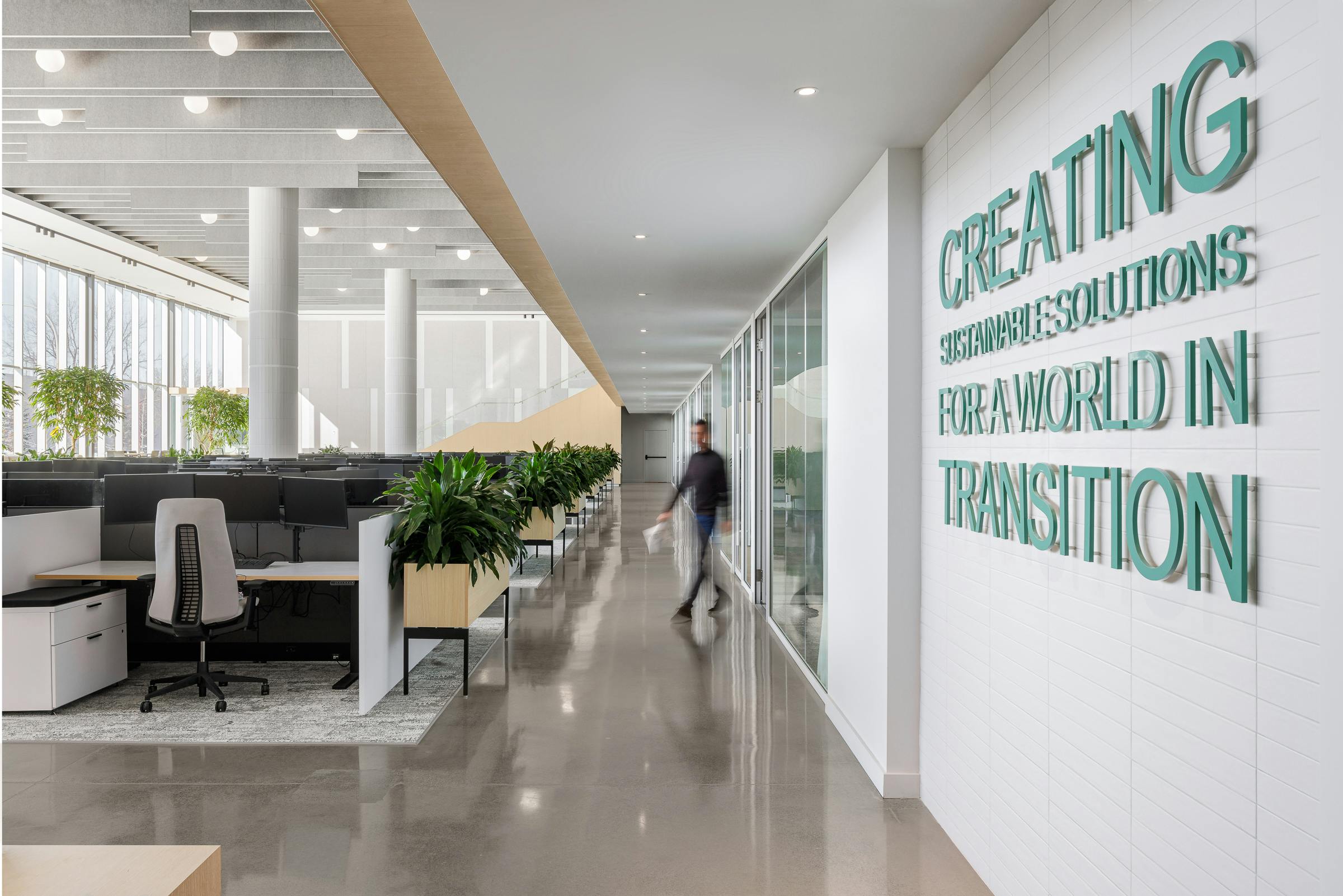 Long corridor crossing workspaces in a renovation with modern interior design.