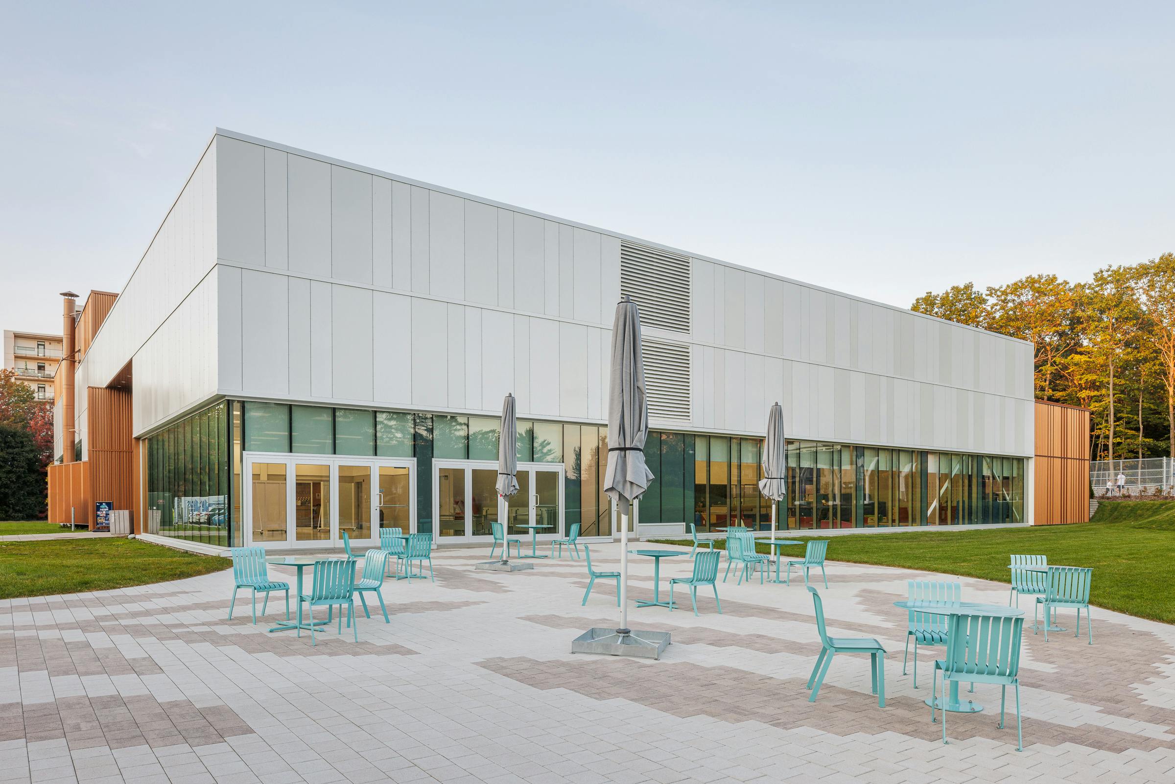 Landscaping and public square next to a sports center with designer urban furniture.