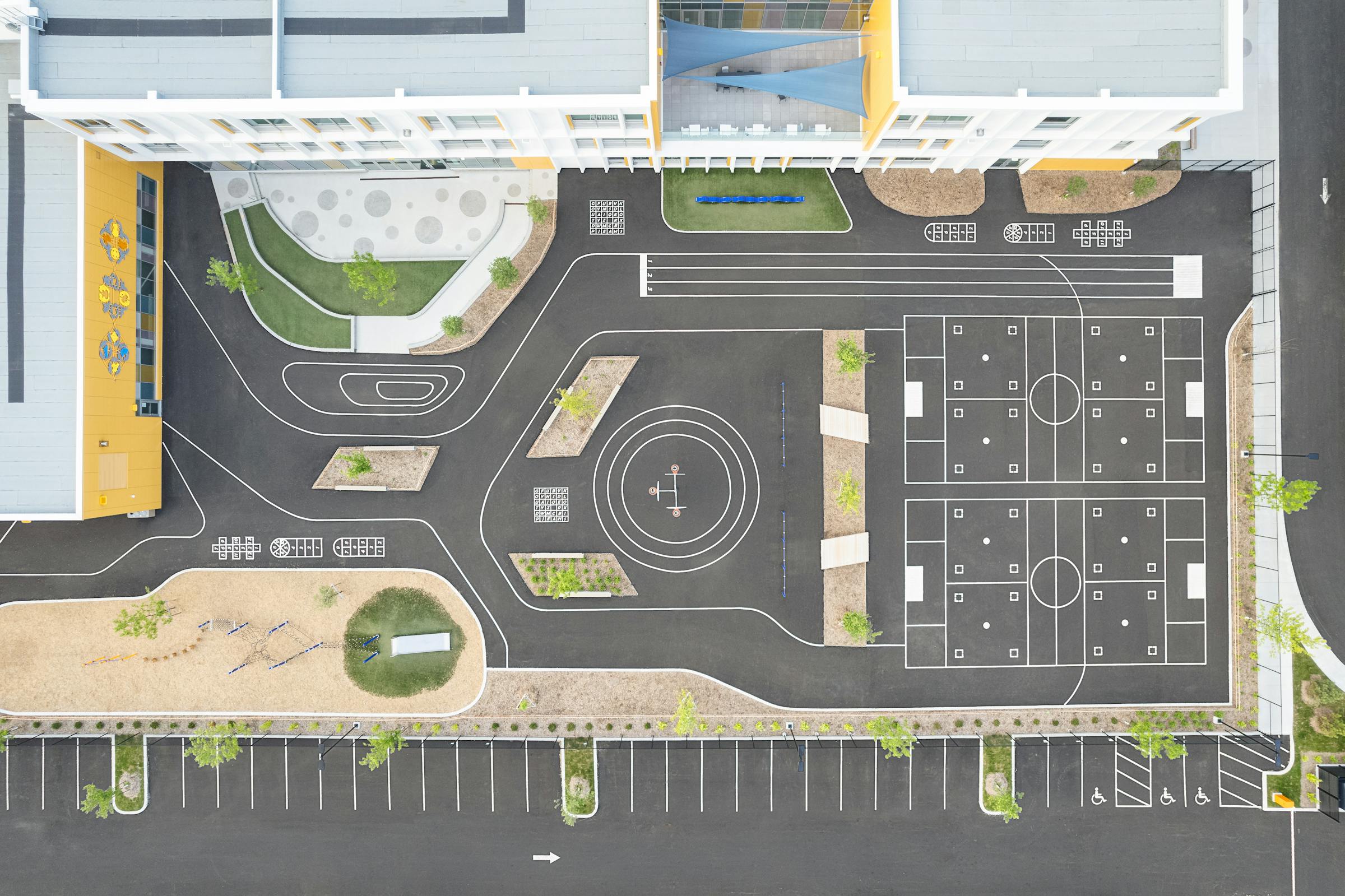 Vue à vol d'oiseau de la cour d'école montrant l'architecture et les aménagements paysagers.