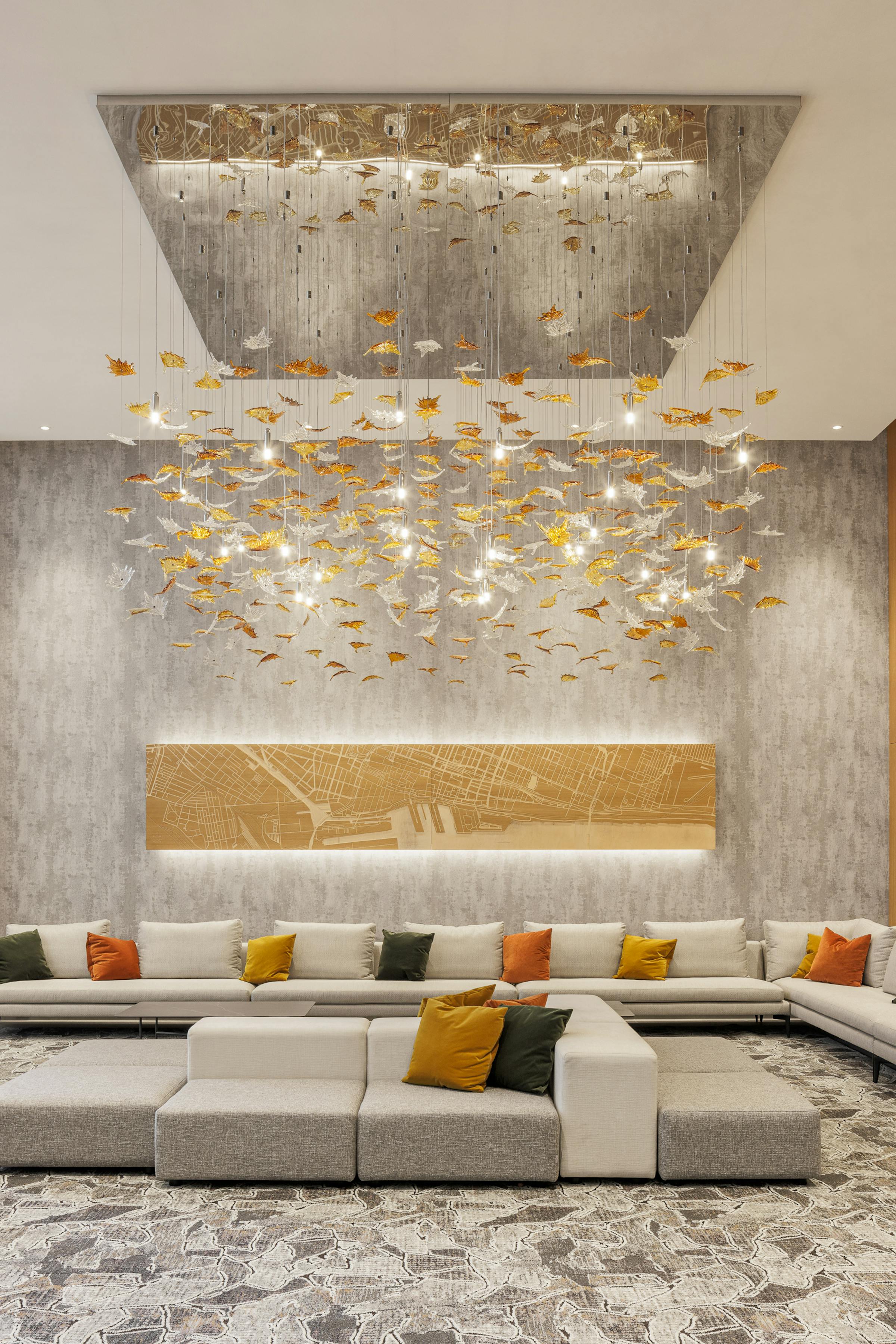 Ambiance lumineuse du lobby avec plafond haut et éclairage suspendu au complexe 700 St-Jacques.